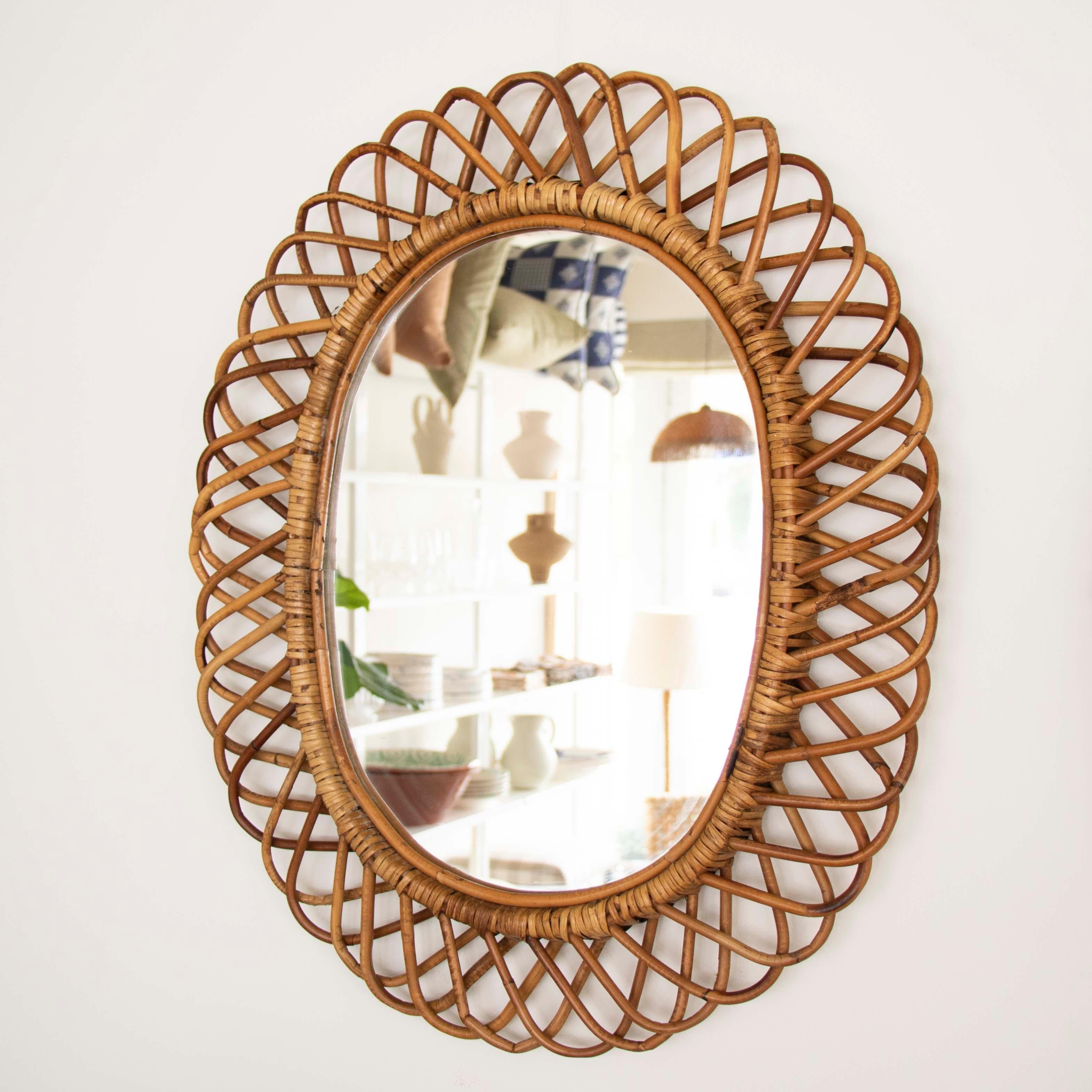 Beautiful oval rattan mirror by of Franco Albini from Italy, 1960's. Wonderful rattan detail encompassing mirror. Nice vintage condition with original rattan frame and mirror. Great size, perfect for powder room or entryway.