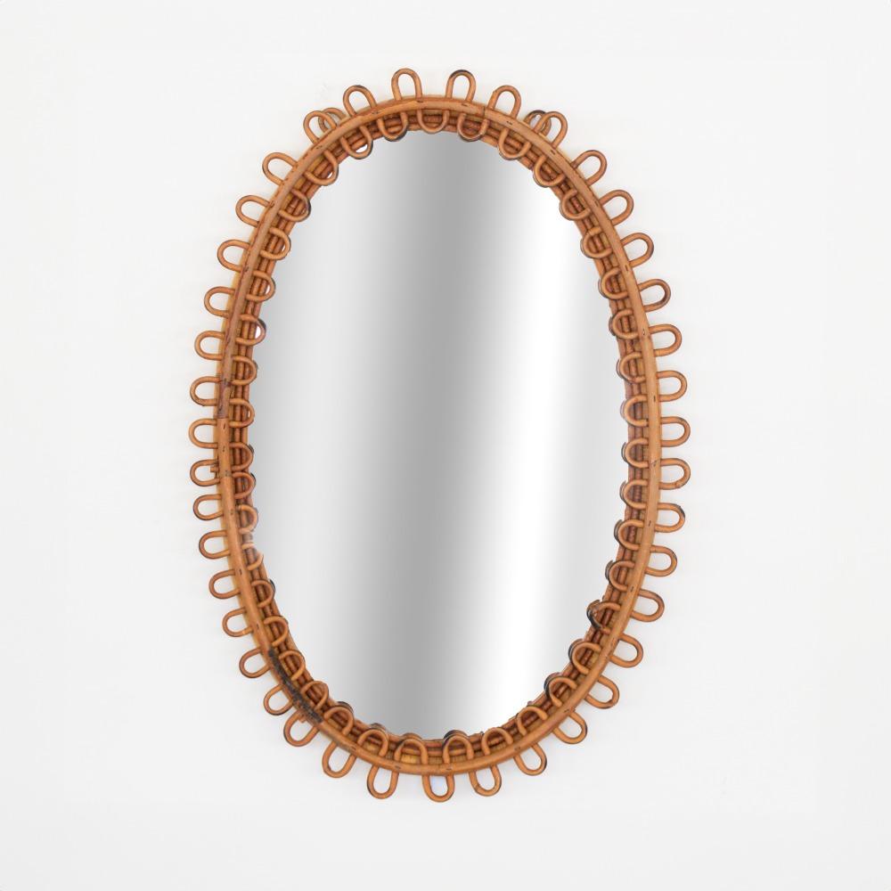 Italian rattan mirror in an oval shape with looping rattan encompassing the mirror. Nice vintage condition with original finish and mirror. Perfect for powder room. Matching pair available. 
