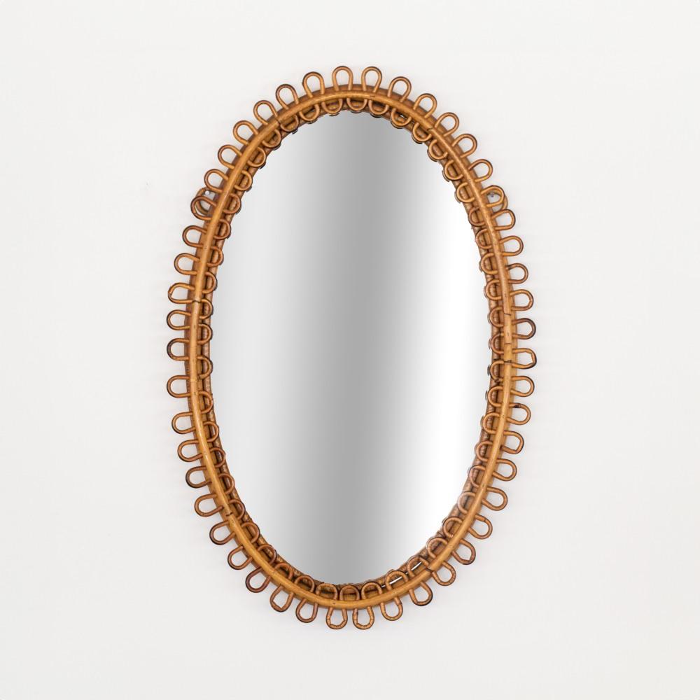 Italienischer Rattanspiegel in ovaler Form mit Looping-Rattan, das den Spiegel umgibt. Schöner Vintage-Zustand mit Originallackierung und Spiegel. Perfekt für den Waschraum. Passendes Paar verfügbar. 