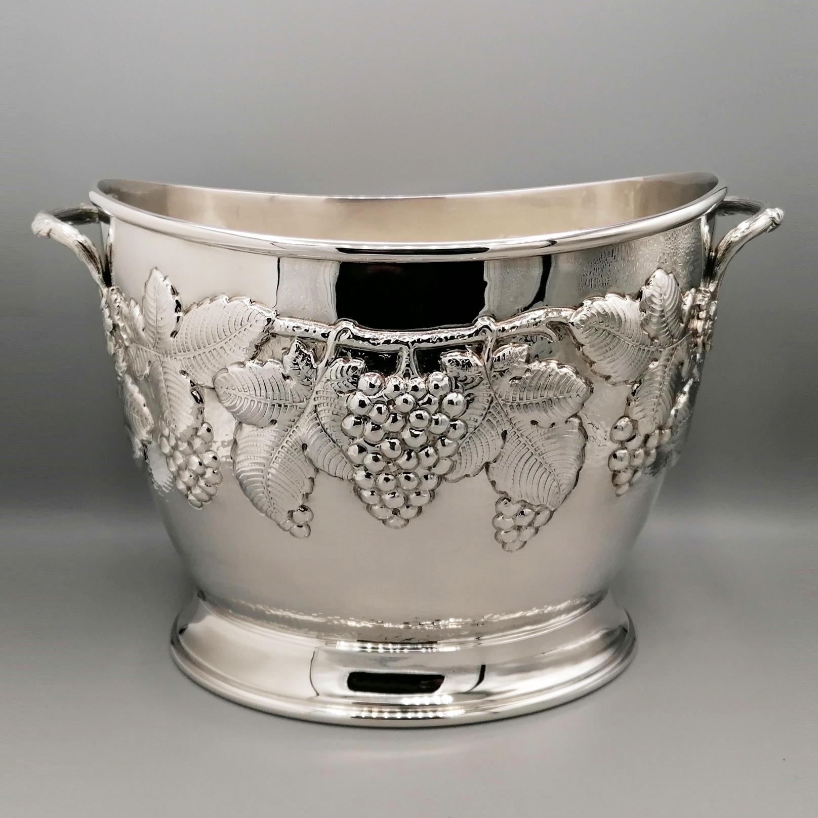 Oval champagne bucket for 2 bottles in solid silver.
The oval body was embossed with a vine shoot design with bunches and grape leaves and subsequently finished with a perfect engraving work to highlight the various details.
Below the embossment,