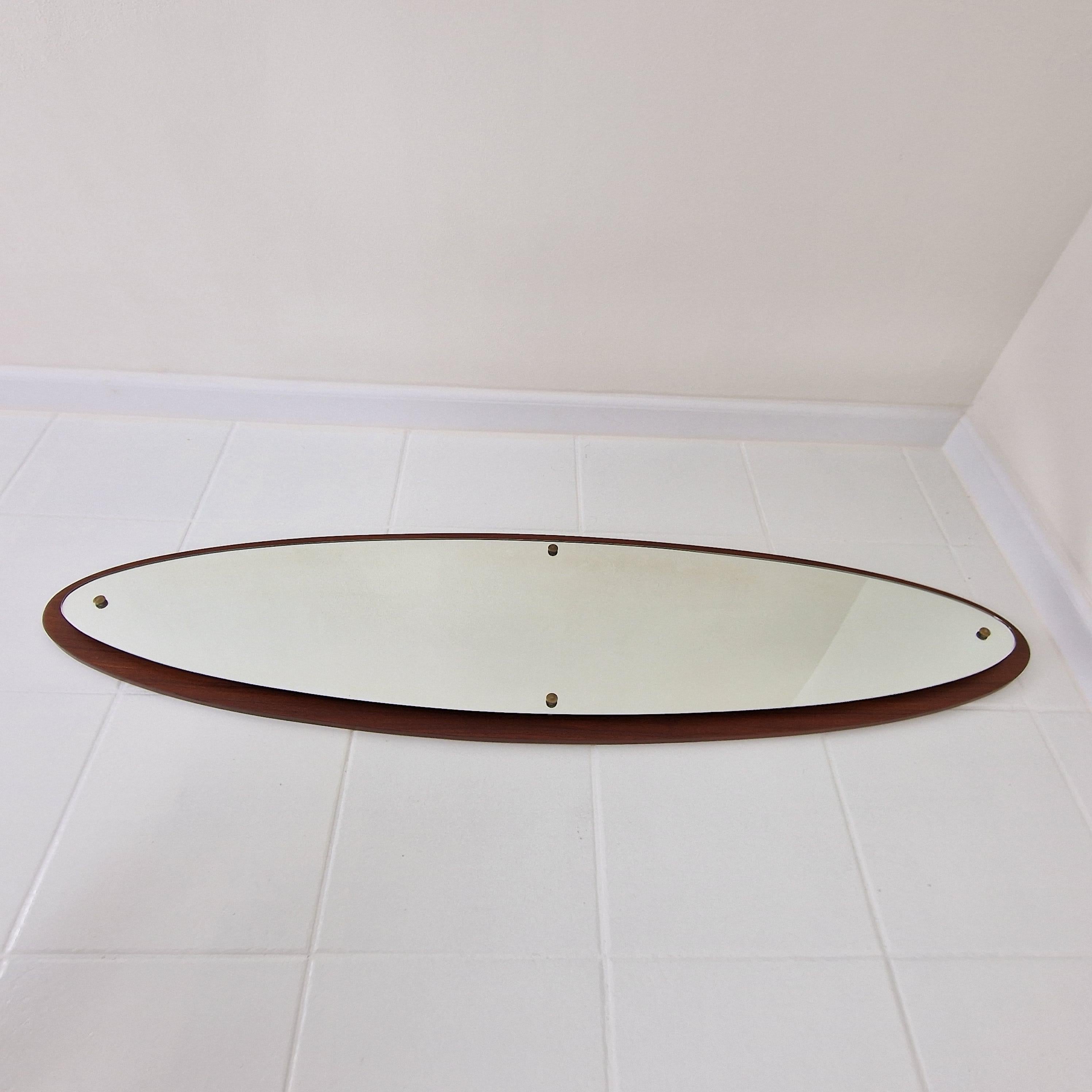 Magnifique et élégant miroir mural ovale en bois de teck. 
Fabriqué en Italie dans les années 1970. 

Au dos, une plaque en bois de teck avec un trou pour l'accrocher au mur. 

Les plus petits signes d'usure vintage mais pas de défauts.

Nous