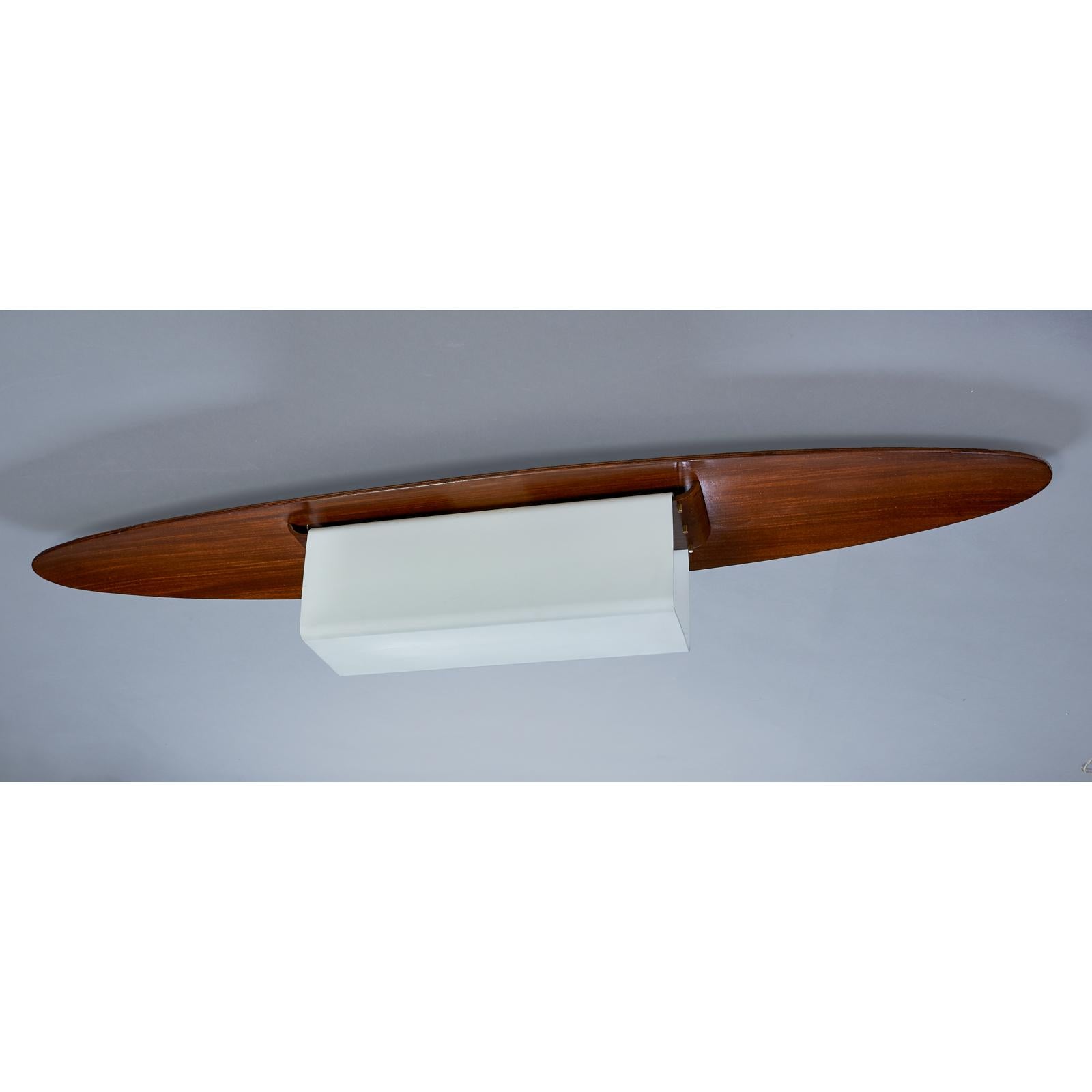 Italy, 1960s
Long oval flush mount ceiling light, opaline squared tubular lamp enclosure suspended from a gracefully curved oval polished wood canopy
Dimensions: 50 W x 12 D x 7 H
Rewired for the US with two standard base bulbs.
 