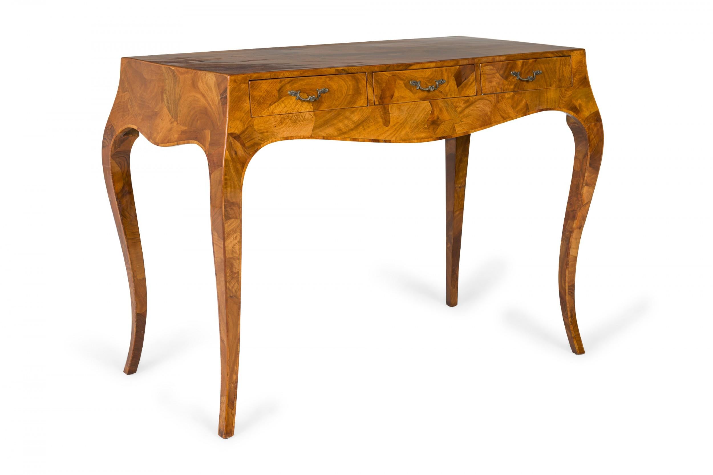 Italian Mid-Century rectangular writing desk with an oyster burl veneer and three drawers, resting on four sabre legs.
