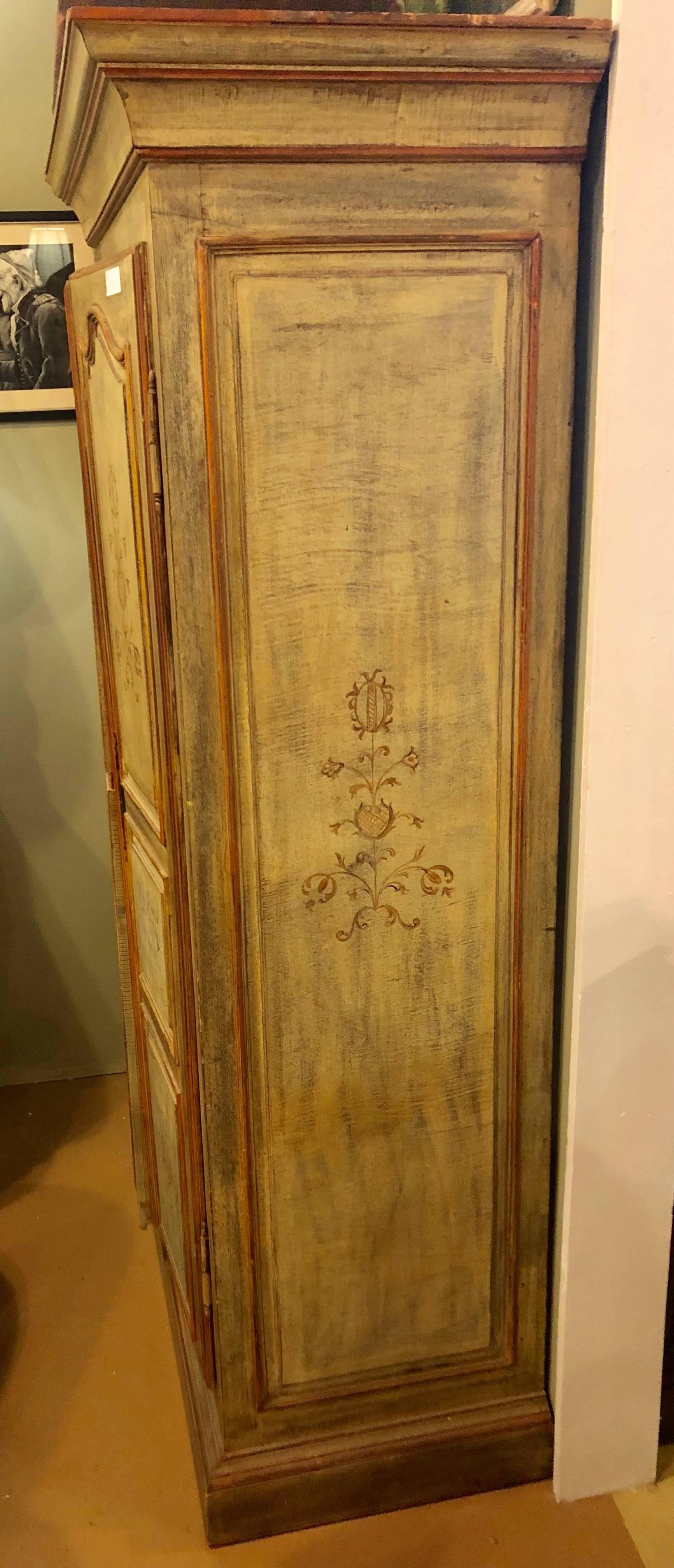 An Italian paint decorated cabinet, armoire or wardrobe. Having two doors leading to a large open shelved (missing shelves) interior.