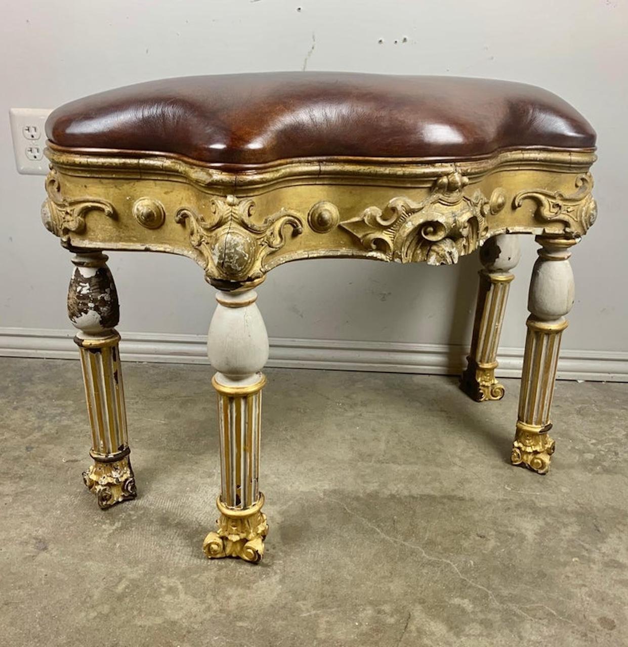 Banc en forme de serpentin réalisé sur mesure avec des pieds cannelés et des pieds en forme de chapiteau peints et dorés à l'ancienne en Italie. La banquette a été récemment recouverte de cuir couleur châtaigne avec des détails en cordelette.