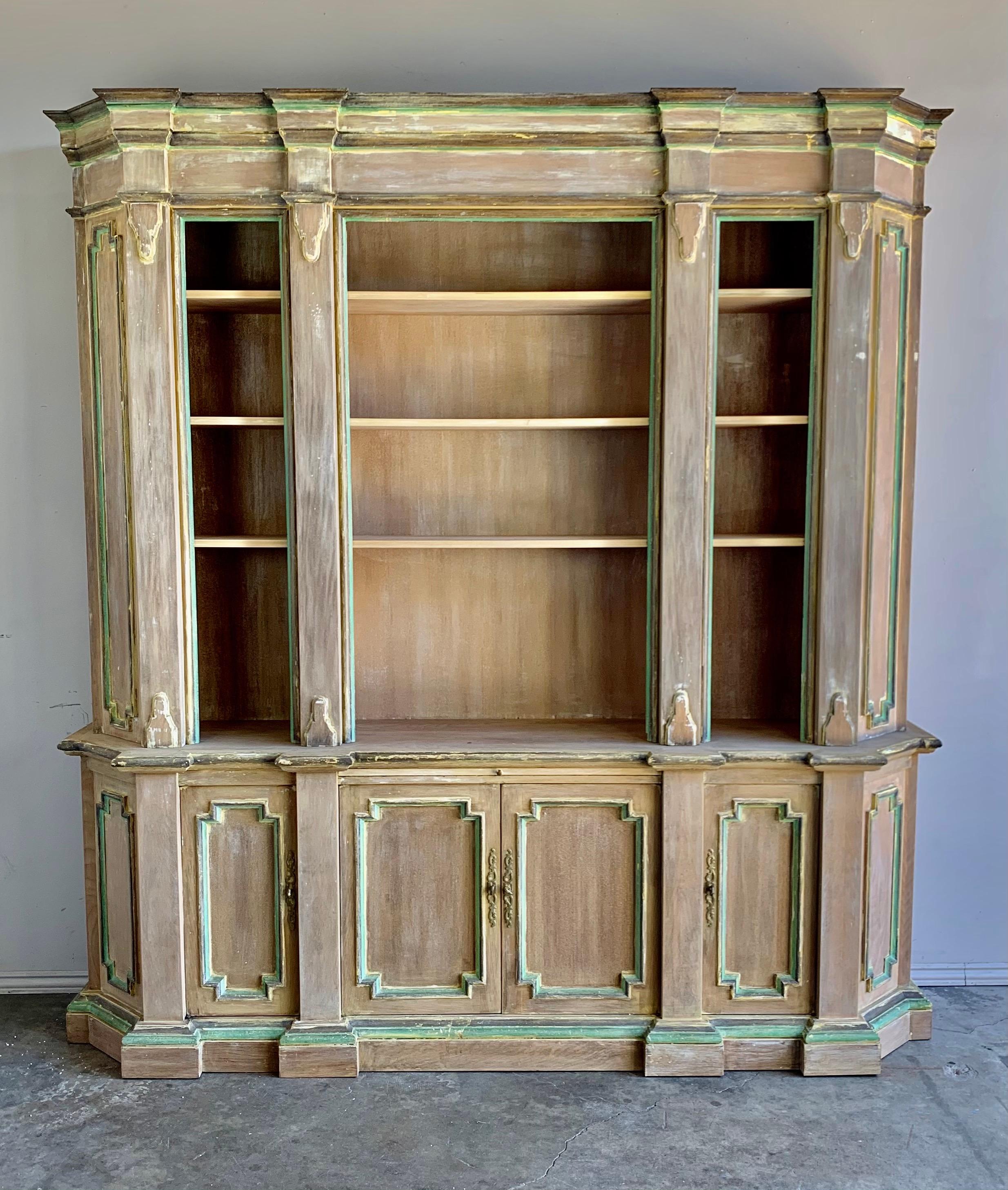 Italian painted bookcase in a soft white wash finish with painted accents throughout. There is storage underneath.