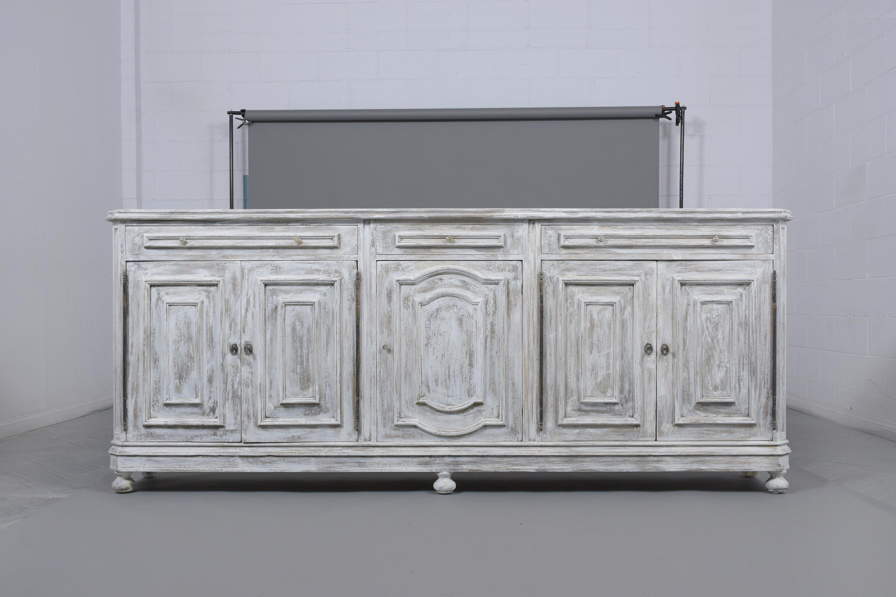 This Italian 1970's baroque-style buffet is hand-crafted out of oak wood, has been newly painted in an off-white and gray color combination with unique distressed finished and has been professionally restored. This server features a marquetry design