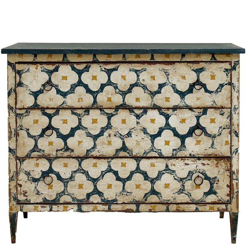 Peinte à la main dans de riches tons d'ivoire, de bleu et de doré, cette commode italienne d'époque présente un design quadrilobé intemporel et une élégante patine vieillie. Avec ses trois tiroirs spacieux et ses gracieux pieds fuselés, il est à la