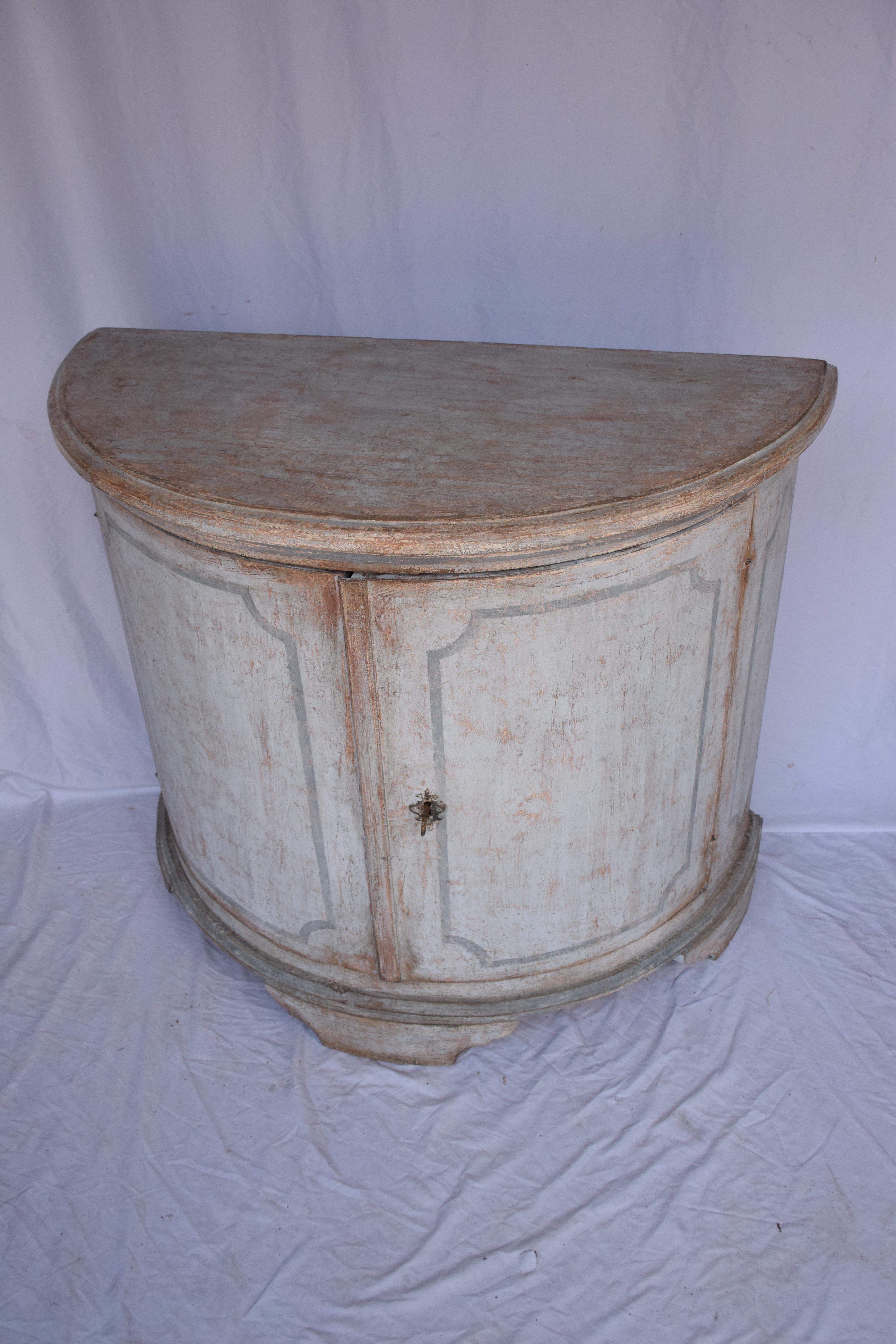 A beautiful Italian demi-lune cabinet with timeless charm. Featuring a hand-painted finish and two doors with key or concealed storage, this piece blends elegance with practicality. Its curved demi-lune shape makes it a standout accent for an
