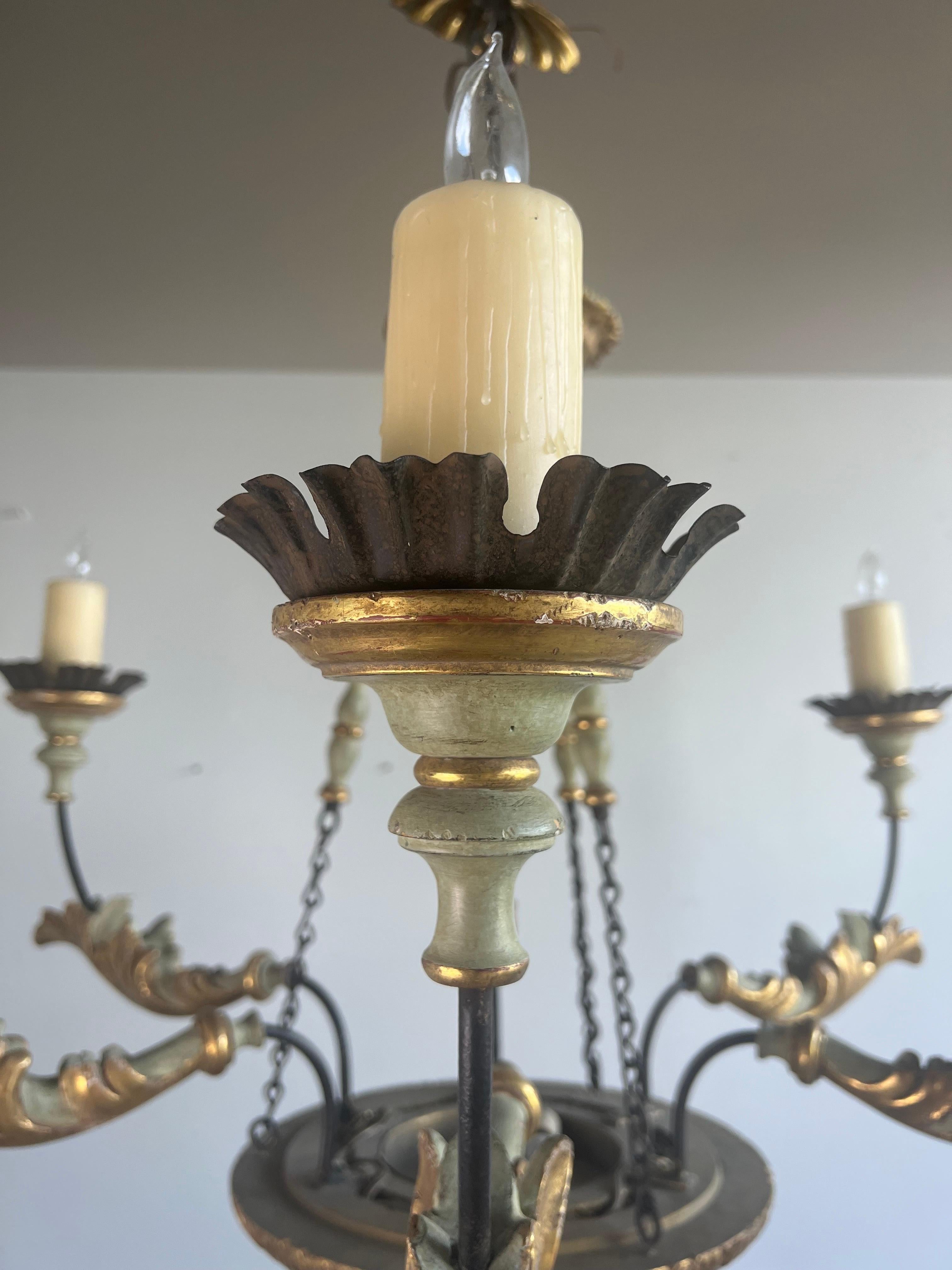 Italian style six light painted and parcel gilt chandelier with iron chain and accents.  Newly rewired with wax candle covers.  Includes chain and a beautiful carved wood canopy.