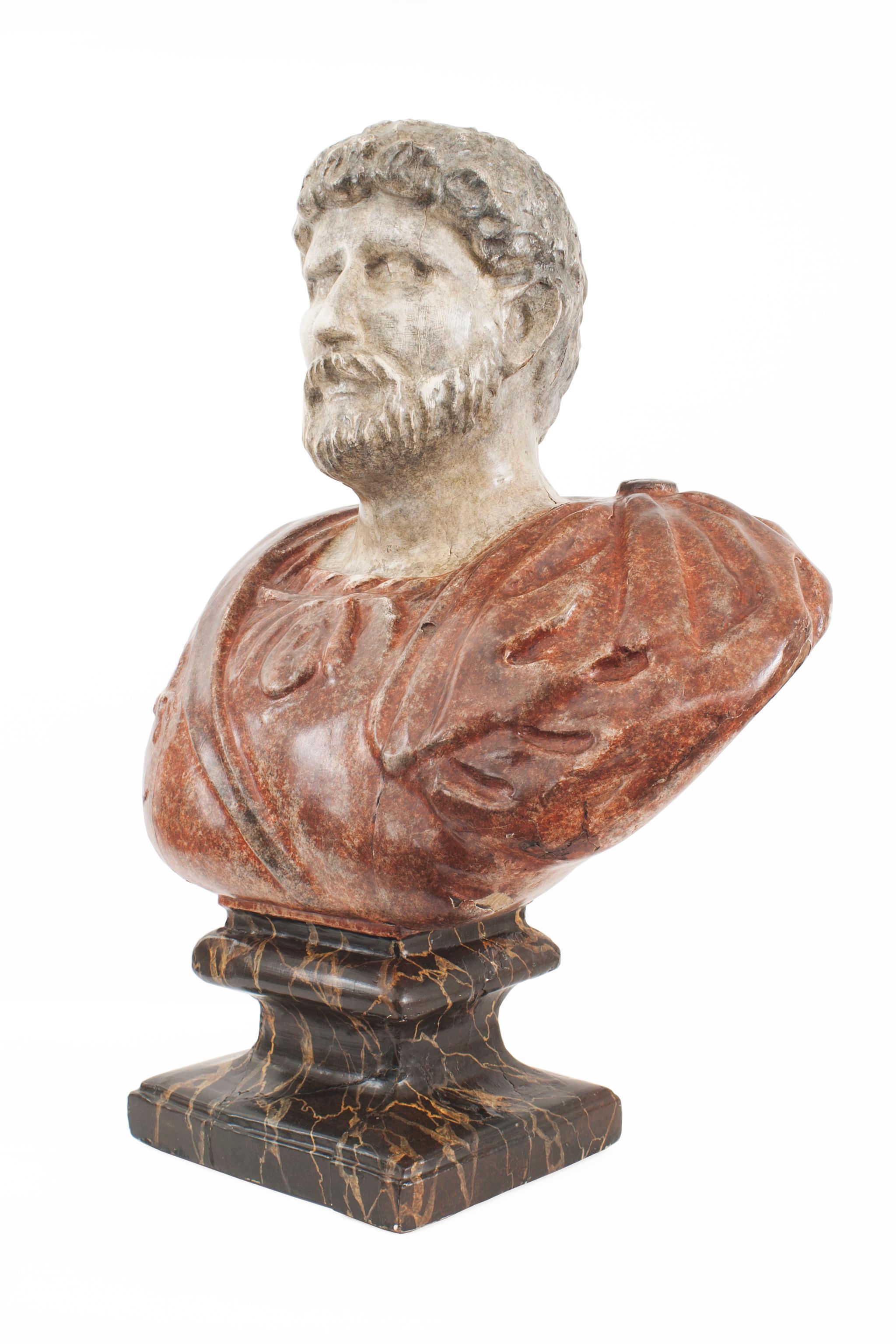 Italian Neo-Classic style (19/20th Cent) faux painted composition bust of a Roman Emperor wearing a red toga and mounted on a black square base.
