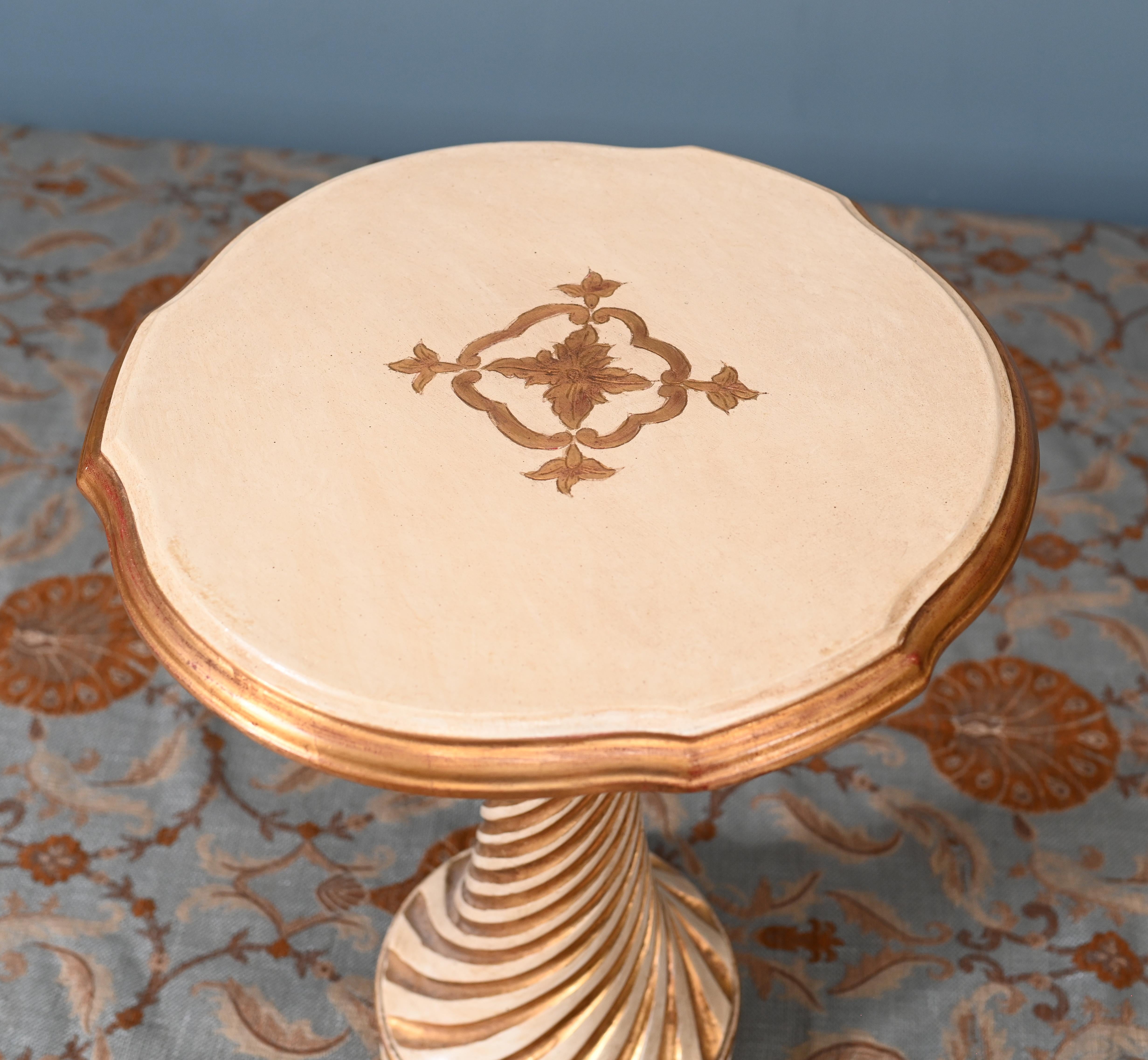 Extravagante mesa auxiliar italiana antigua pintada con detalles dorados Circa 1930
El elemento más destacado es la columna giratoria en espiral, ricamente tallada y acabada en una paleta de marfil y pan de oro envejecido que rezuma elegancia