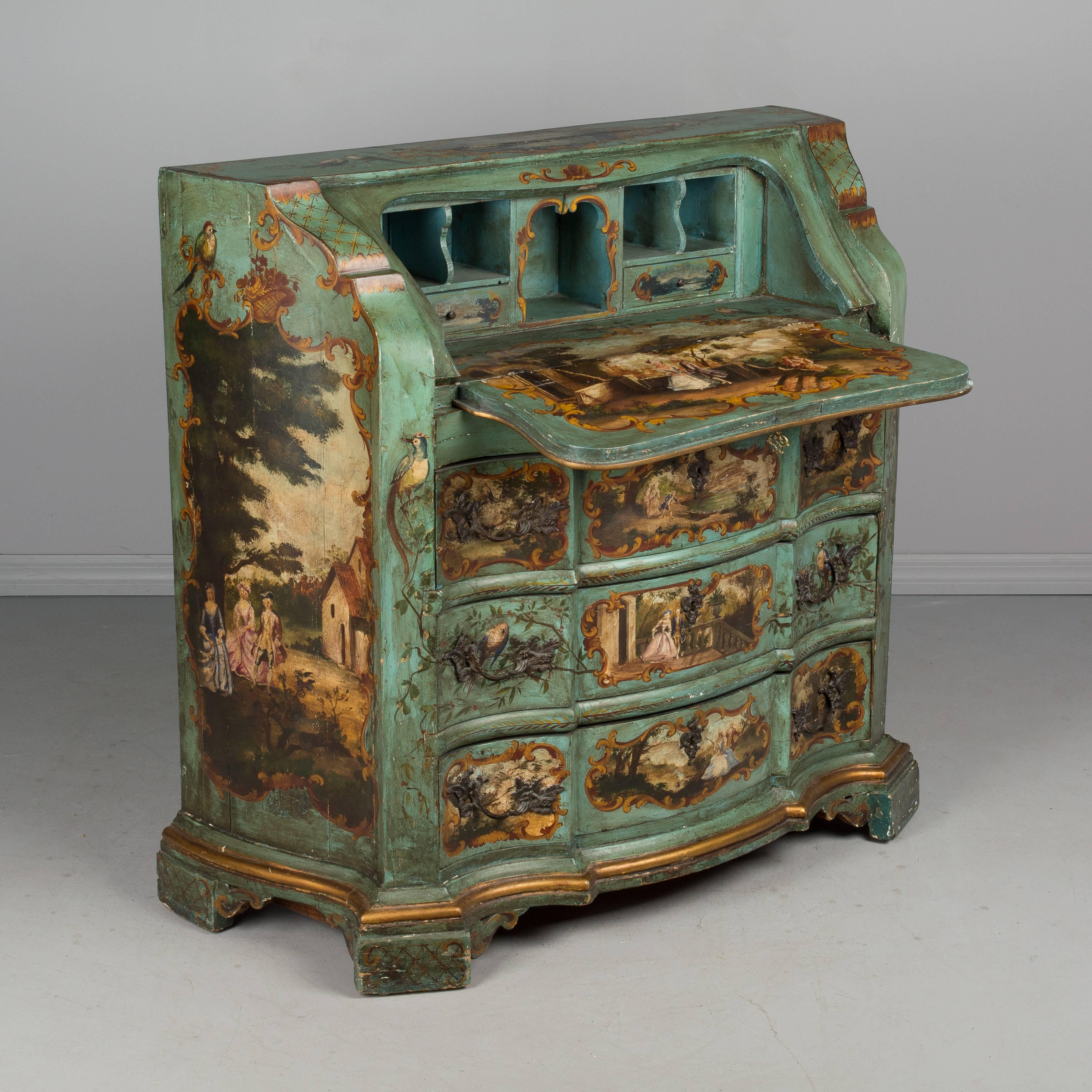 An Italian painted pine slant front desk with serpentine sides and arbalete front. Beautifully painted with romantic rococo style pastoral vignettes, birds and flowers and accented with gold borders. Desk opens to painted surface with small drawers