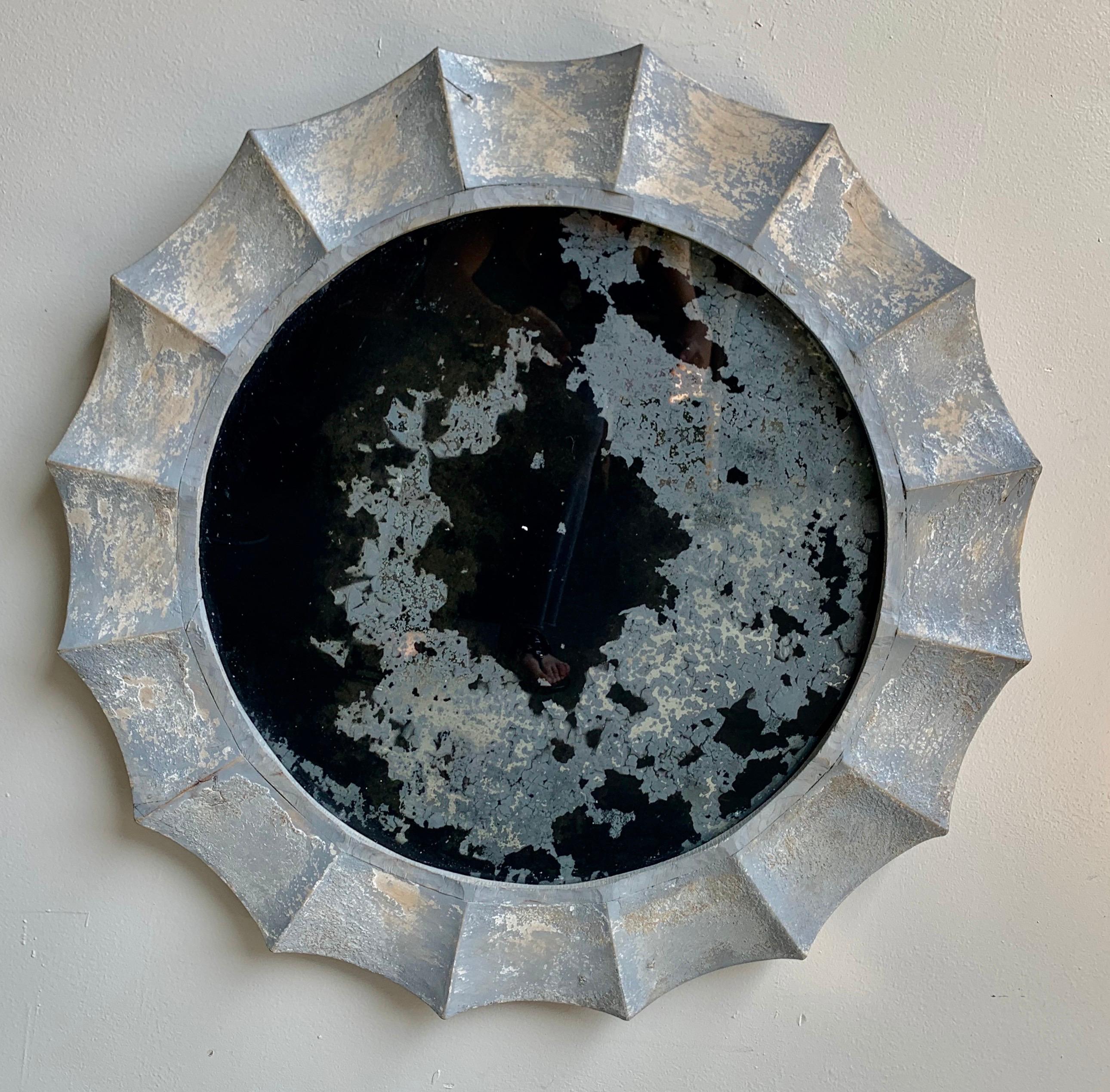 Italian painted sunburst style mirror with a distressed painted finish in soft shades of blue and cream. The mirror has a great scalloped edge and appears to have a modified sunburst mirror shape. The glass is completely antiqued and cannot be used