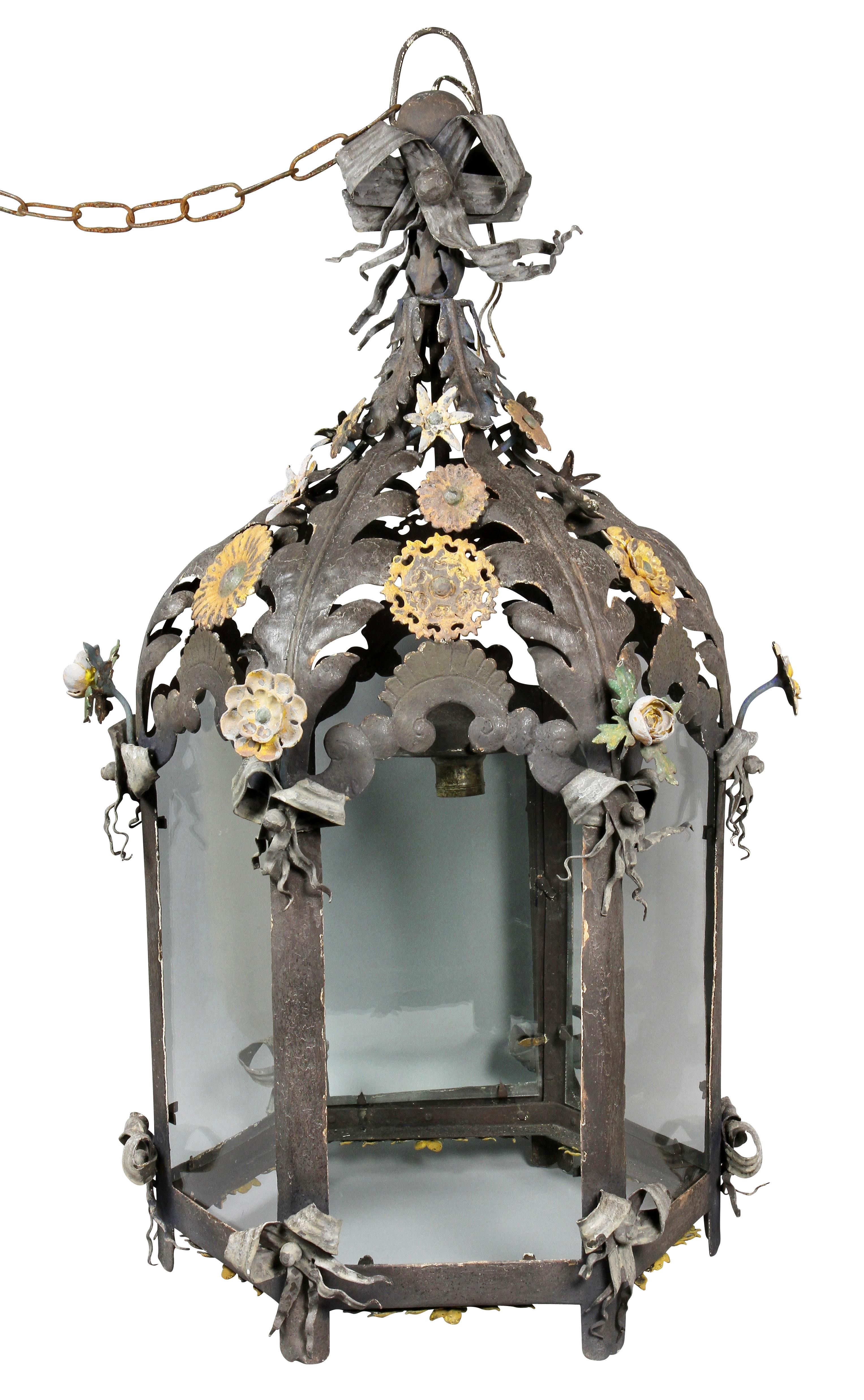 Domed top with leaf decoration and flower heads, cylindrical body with glass panels.