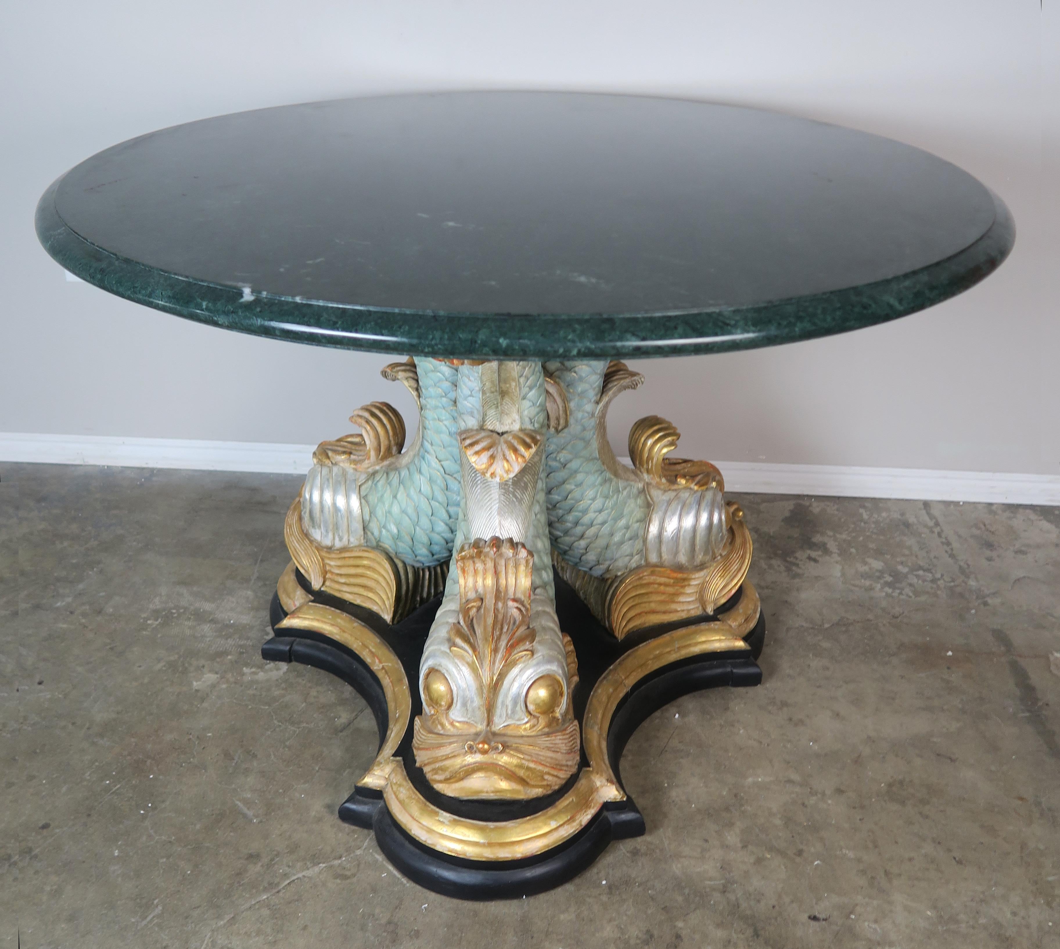 Italian soft aqua painted and parcel-gilt tripod dolphin carved wood table base. A green marble top with a single ogee and bullnose edge detail sits on the whimsical base.