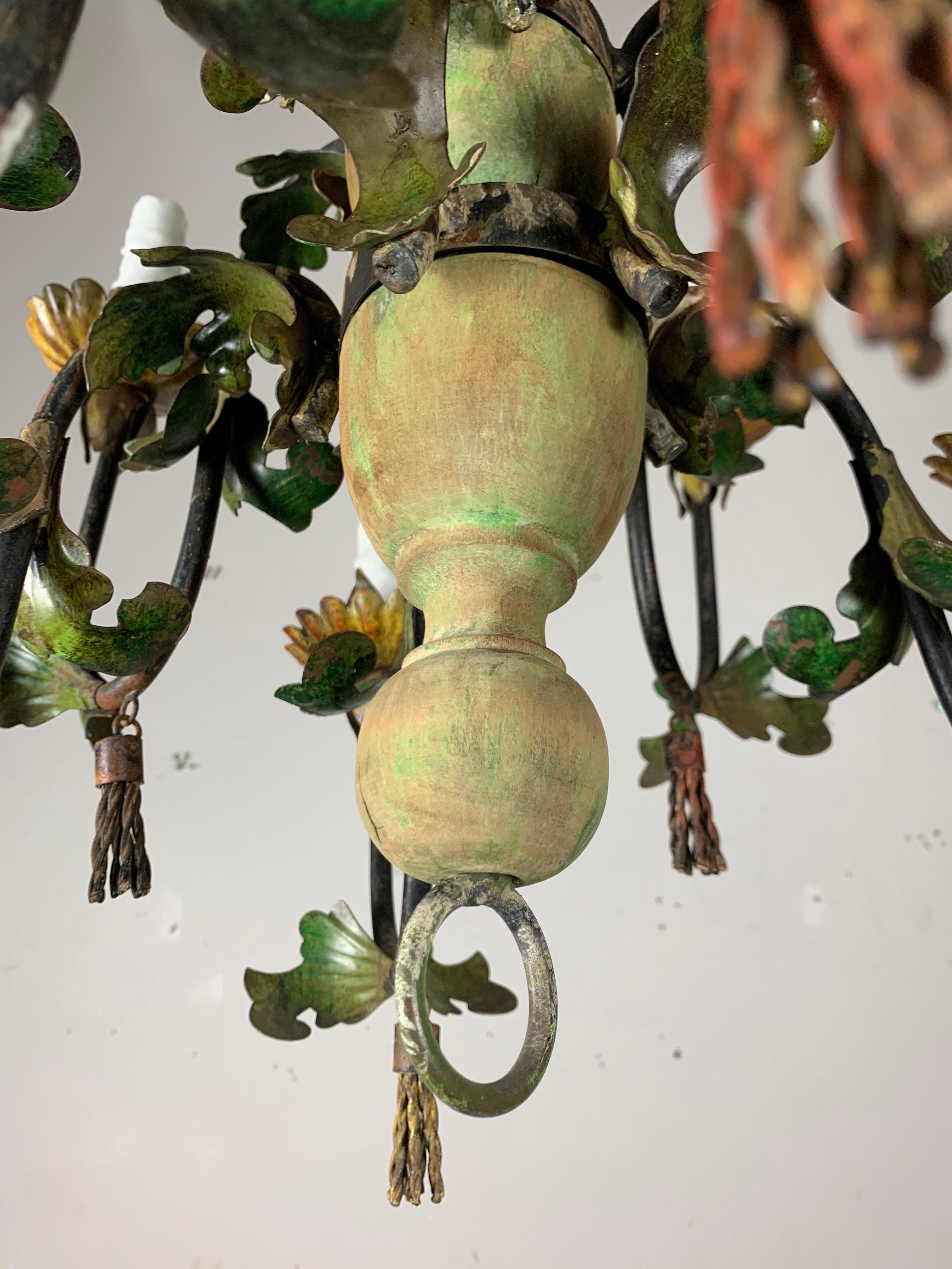 1930's Italian wood & metal painted 8-light chandelier with floral bobeches and metal tassels hanging throughout. It is painted is soft shades of greens and rust coloration. The fixture is newly rewired with cream colored drip wax candles. Includes