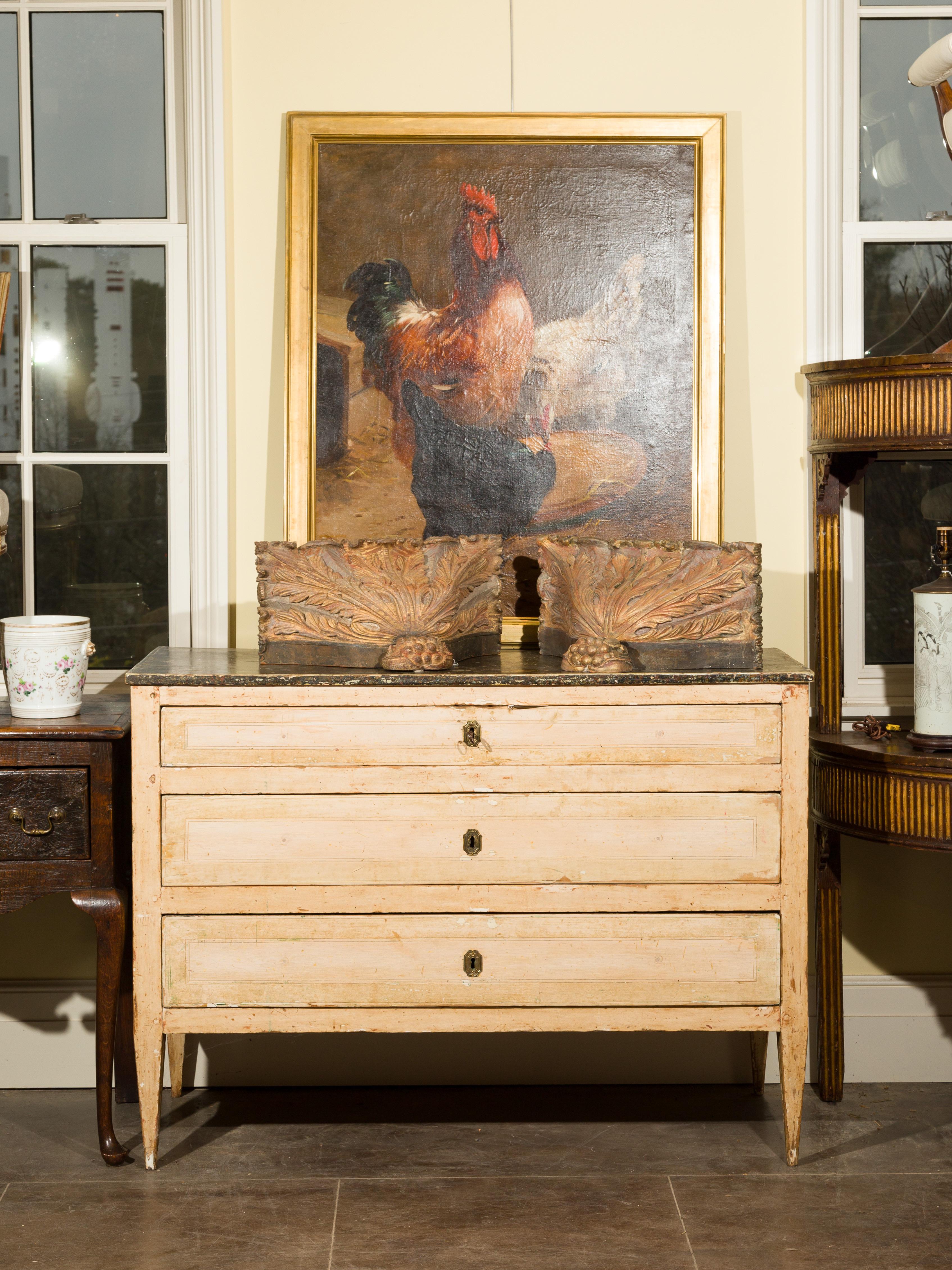 This Italian painted three-drawer commode from the early 19th century features a dark rectangular top over a tan colored body with traces of green accents. Three drawers make up the front, the upper one being thinner than the two others. The