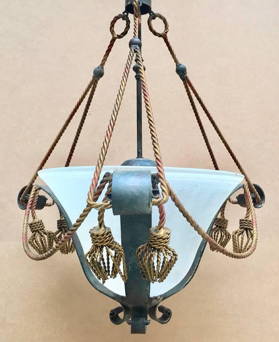 Vintage Italian iron chandelier with gilt twisted iron tassels. Wired with three sockets (40-60 watts each) so provide plenty of light. The globe is glass with a frosted sanded surface.


 