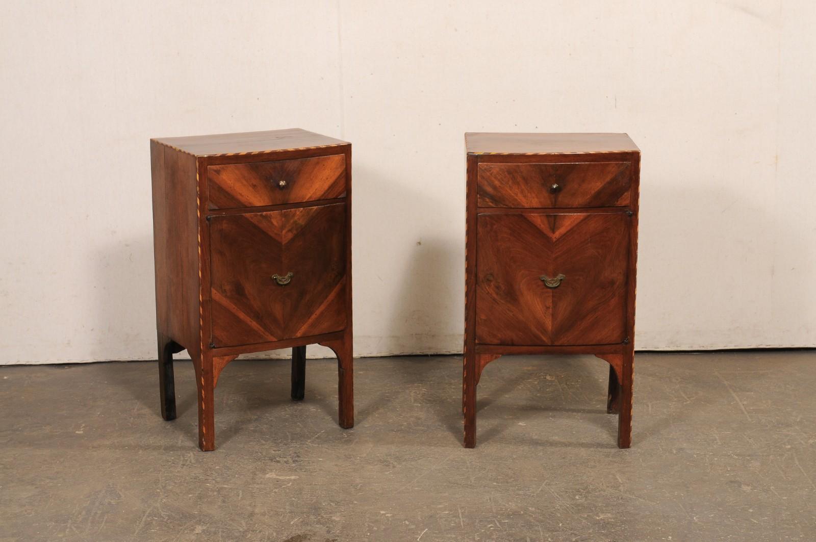 An Italian pair of wooden side chests with veneers and decorative inlay banding, from the 19th century. These antique smaller-sized chests from Italy have a slightly bowed front design, and cases house a single drawer at top with door below, with