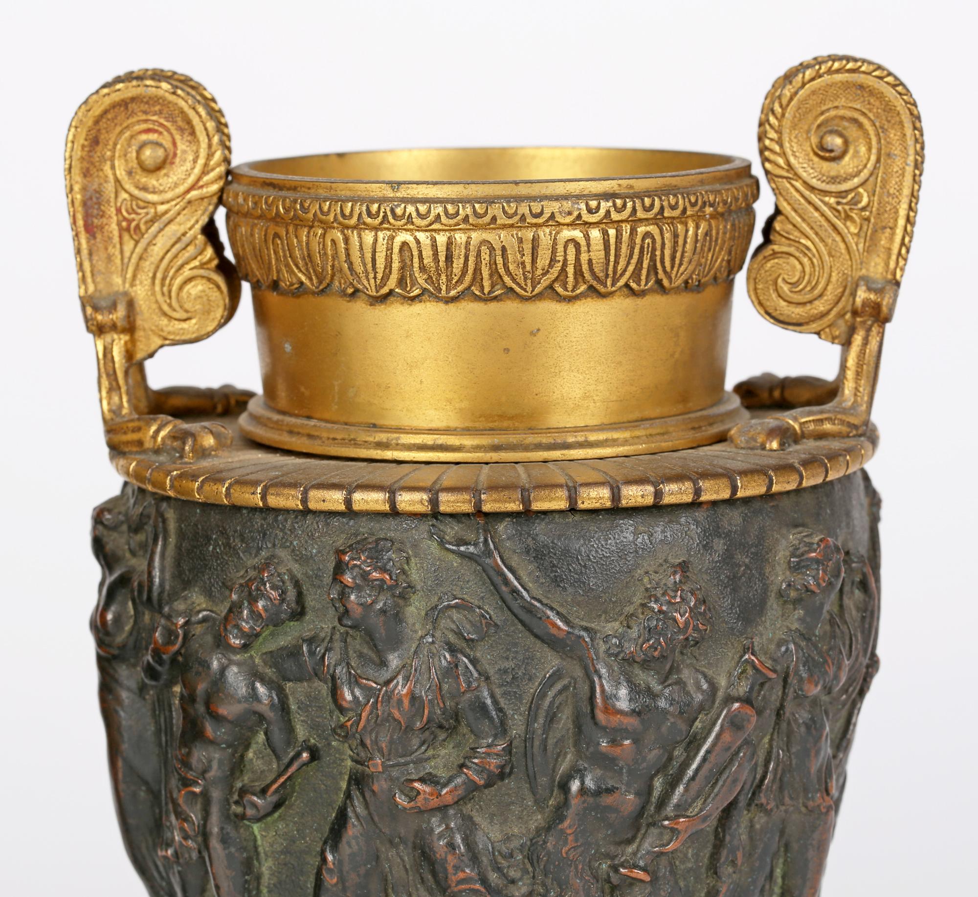 A stunning pair antique Italian Neo-Classical gilt mounted bronze handled urns with classical figural friezes probably made for the grand tour and dating from the mid-19th century. These stylish urns stand on a rounded gilded stepped foot with a