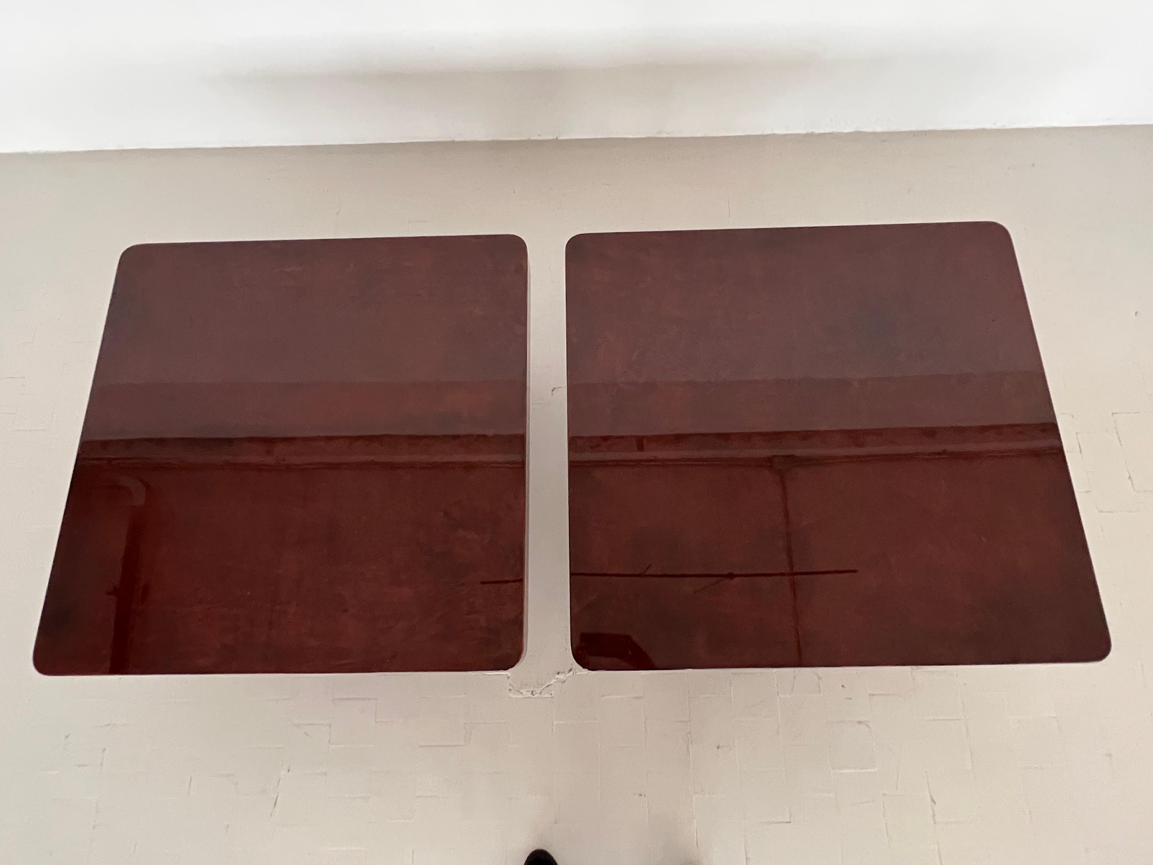 Exceptionnelle et magnifique paire de tables basses conçue par Aldo Tura au cours des années 1970.
Les tables ont été recouvertes de papier parchemin de couleur rouge-brun-mahogany et finies avec une laque forte et brillante.  De belles pièces