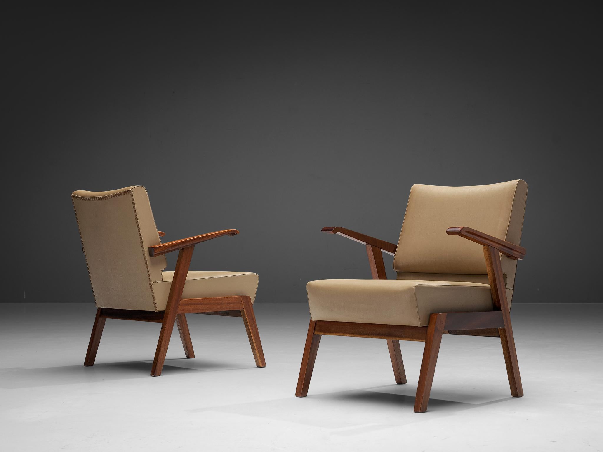 Pair of armchairs, faux leather, walnut, metal. Italy, 1960s

These delicate lounge chairs from Italy are characterized by an angular open framework executed in walnut. The beige upholstery in combination with the deep warm tone of the wood provides