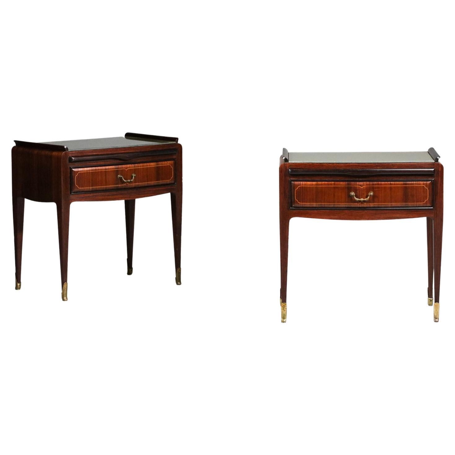 Pair of 60's bedside or night tables by Vittorio Dassi. Structure in rio rosewood, feet and handles in solid brass. These bedside tables have a drawer, a retractable shelf and a glass top. Note the nice brass inlay detail on the drawers which