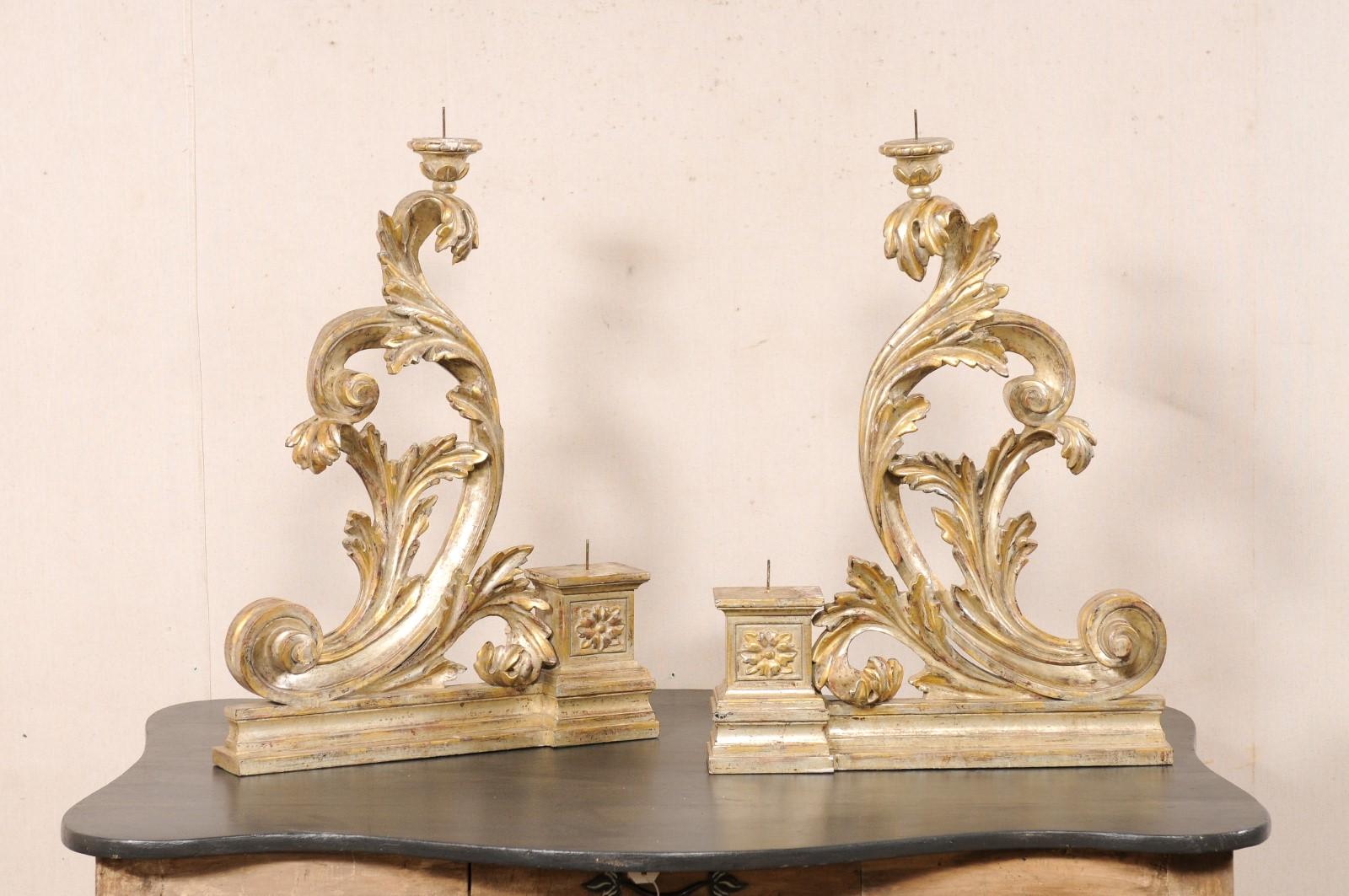 Coppia di portacandele italiani intagliati e dipinti della metà del XX secolo. Questa coppia di portacandele decorativi d'epoca, proveniente dall'Italia, è caratterizzata da un design a foglie d'acanto a scorrimento e da due pinnacoli a due livelli