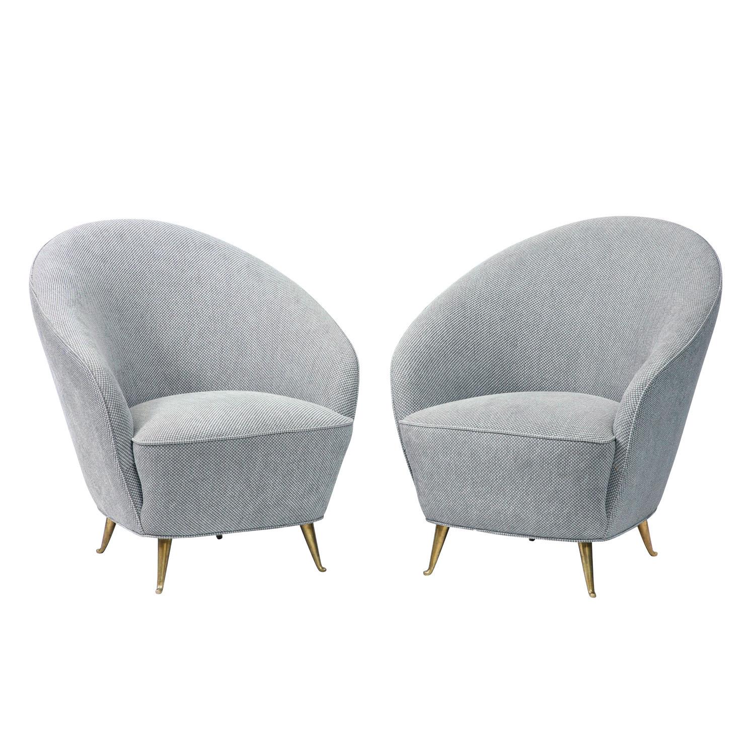 Pair of elegant curved back lounge chairs with solid brass legs, Italian 1950's.  These have been newly reupholstered by Lobel Modern in a beautiful blue/gray fabric.  They are extremely chic and comfortable.  
