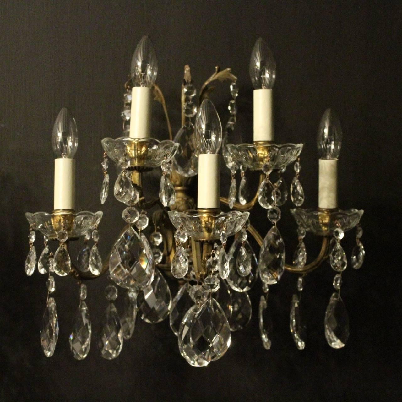 A large Italian pair of gilded cast bronze and crystal five-arm double tiered antique wall lights, the scrolling arms with glass bobeches drip pans and bulbous leaf candle sconces, issuing from a foliated leaf backplate with large leaf outcrop