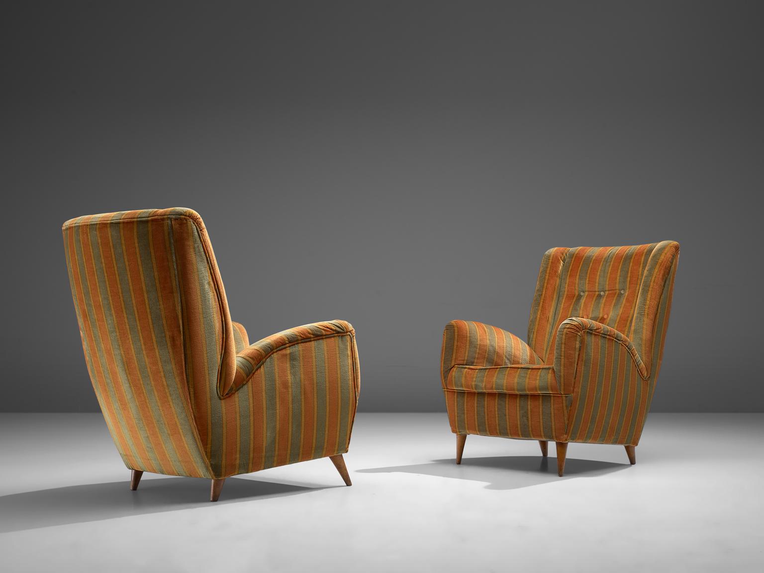 Pair of lounge chairs, fabric and wood, Italy, 1950s. 

An elegant pair of Italian Lounge chairs in the manner of Gio Ponti. What really characterizes these chairs are their theatrical, uplifting armrests and medium high back in combination with