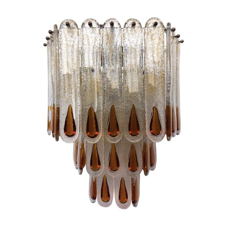 Marvelous, large and unique pair of Italian amber Murano glass wall sconces from 1970s.
These sconces were made during the 1970s in Italy for the Venice Company “Mazzega”.
Each wall sconce is composed by 22 units of Murano glasses (H 11.81 in. 30