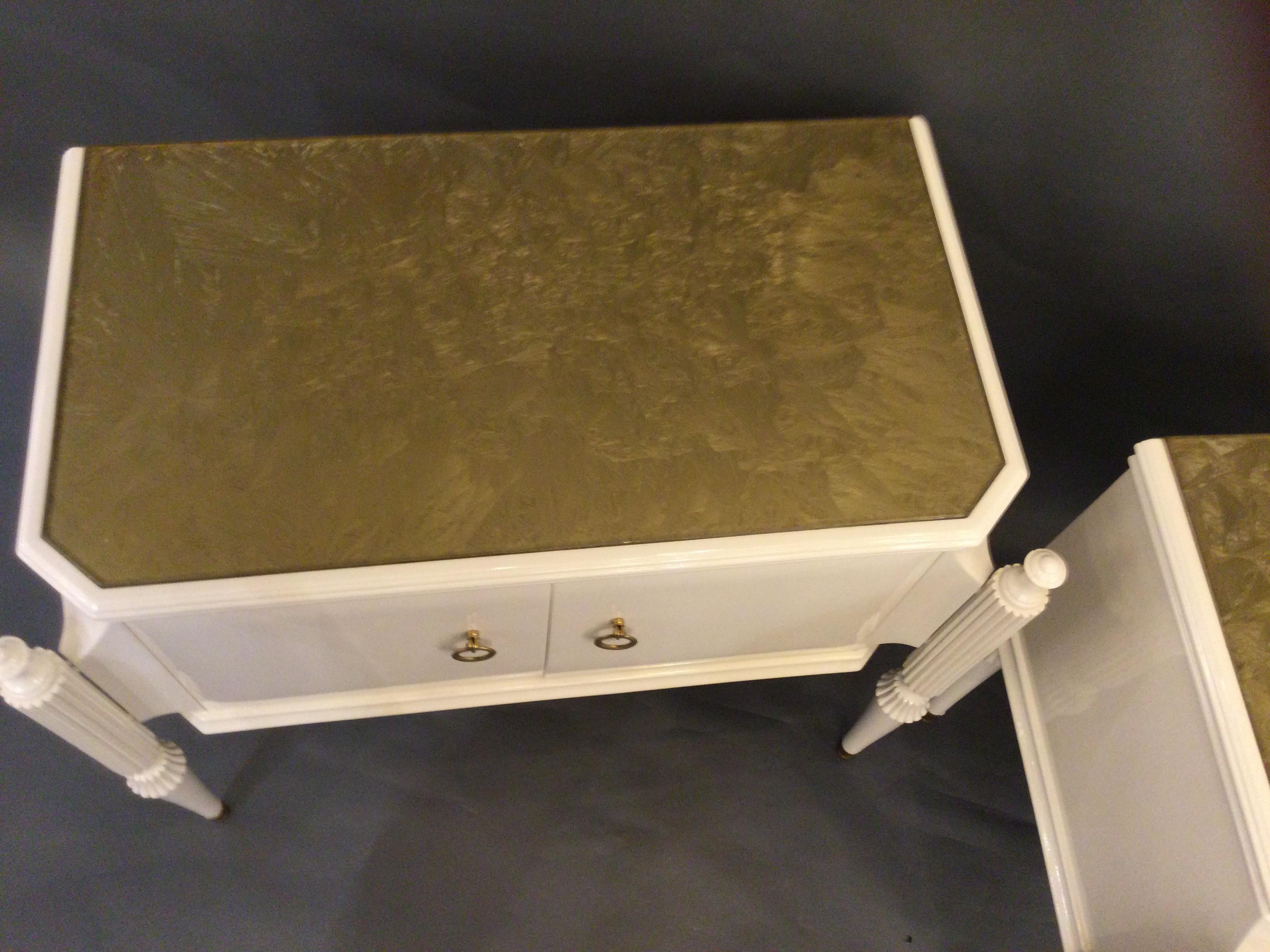A stunning pair of side tables in lacquered wood, gold glass top, two doors, brass feet and handles with original patina.
This elegant pair of tables would look stunning in any interior.