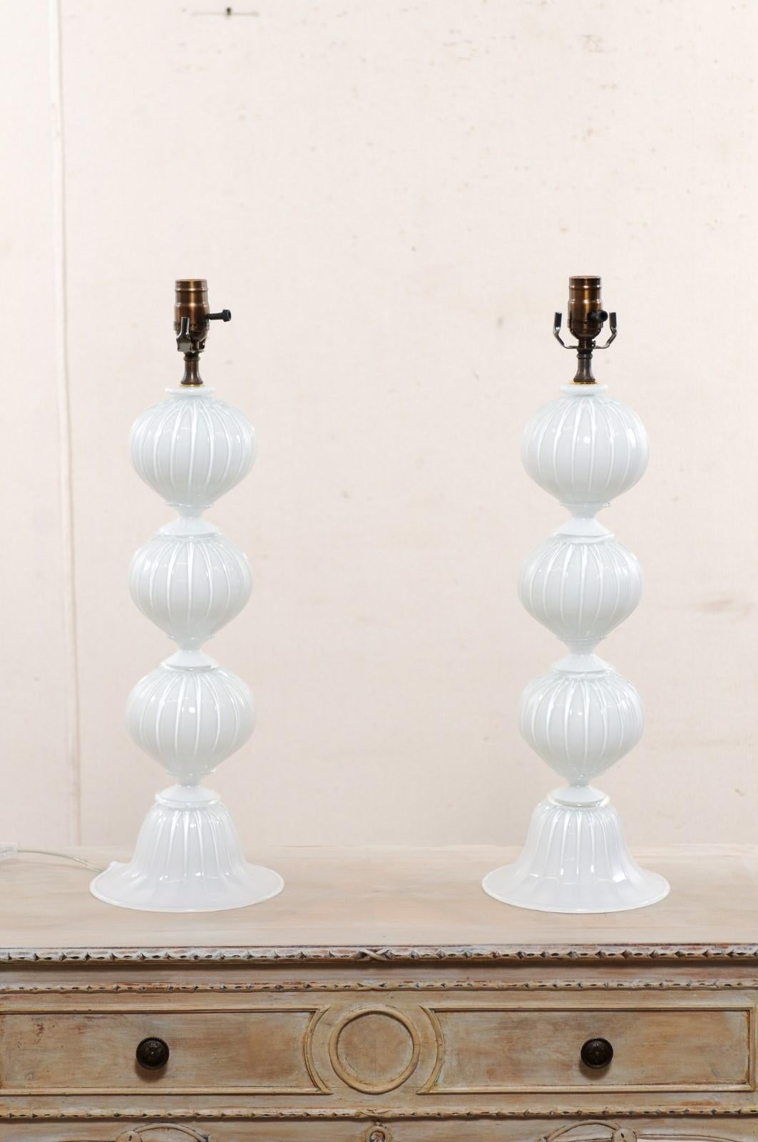 An Italian pair of hand-blown murano glass table lamps These classic designed Italian table lamps, created by expert glass masters in the Venetian island of Murano, Italy, each lamp features a beautifully stacked column of striped spheres in a