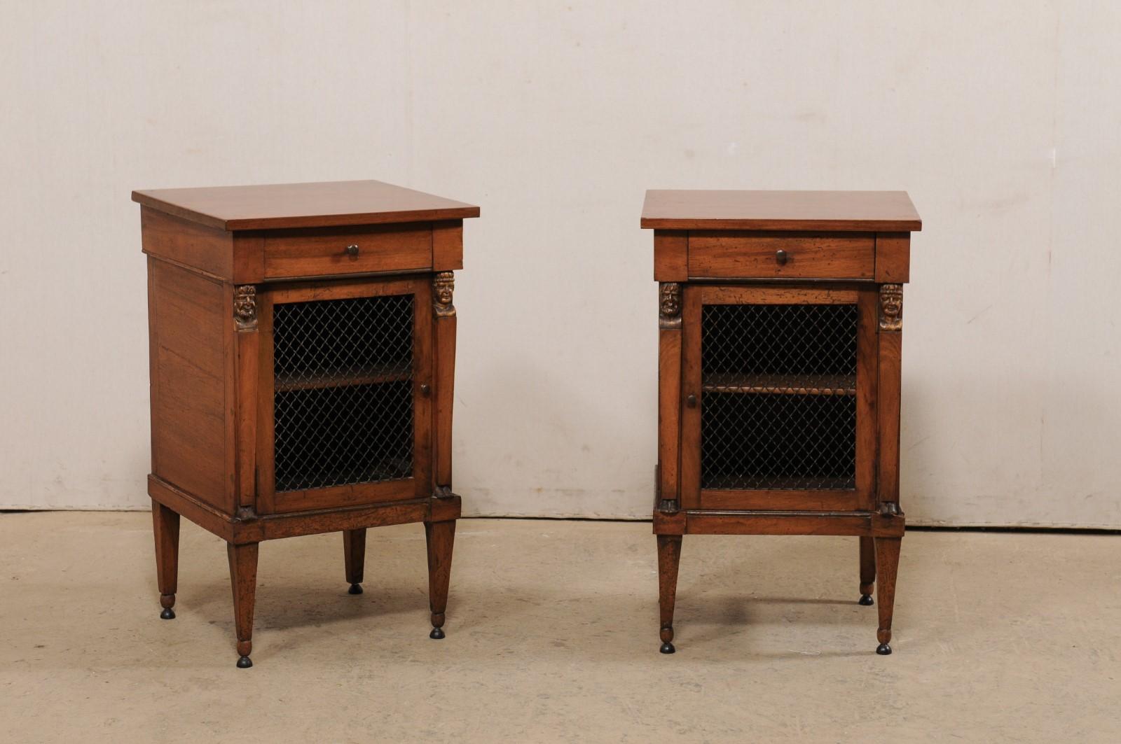 An Italian pair of petite side cabinets with from the 19th century. This antique pair of cabinets from Italy each have a case designed with clean lines, which houses a small drawer atop a wire-front door, flanked within column-style side posts with