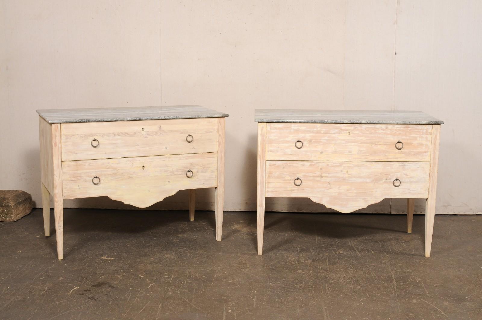 Paire de commodes italiennes à deux tiroirs surélevés, avec dessus en marbre, de la fin du 20e siècle. Ces coffres vintage d'Italie présentent chacun un plateau de marbre gris de forme rectangulaire, qui repose sur la caisse en bois abritant deux