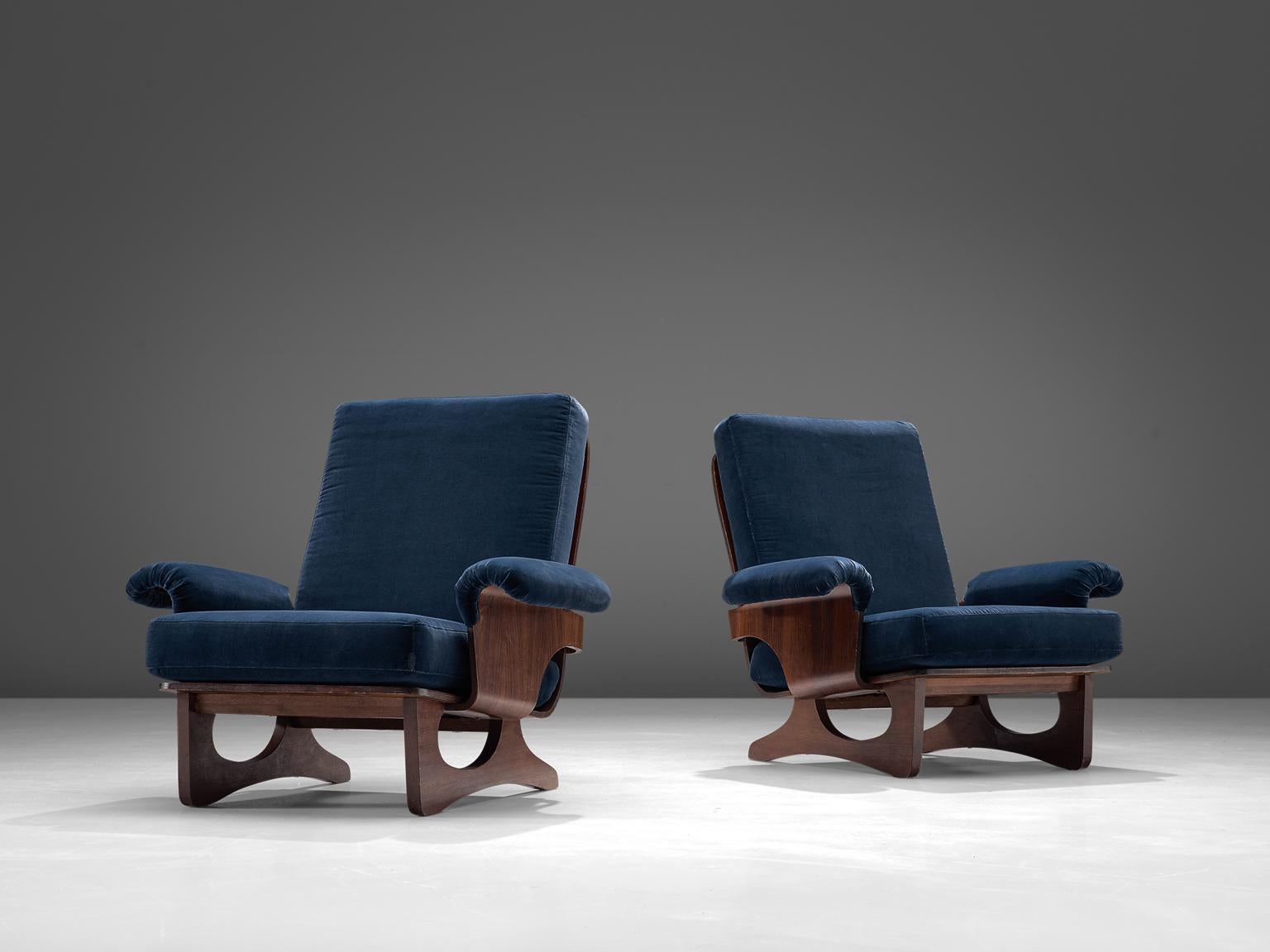 Silvio Cavatorta, pair of lounge chairs, blue velvet and rosewood, Italy, 1960s.

Armchair with rosewood frame and blue velvet upholstery. The seating and back are nicely curved. Nicely designed legs with folded armrests. The rosewood frame shows a