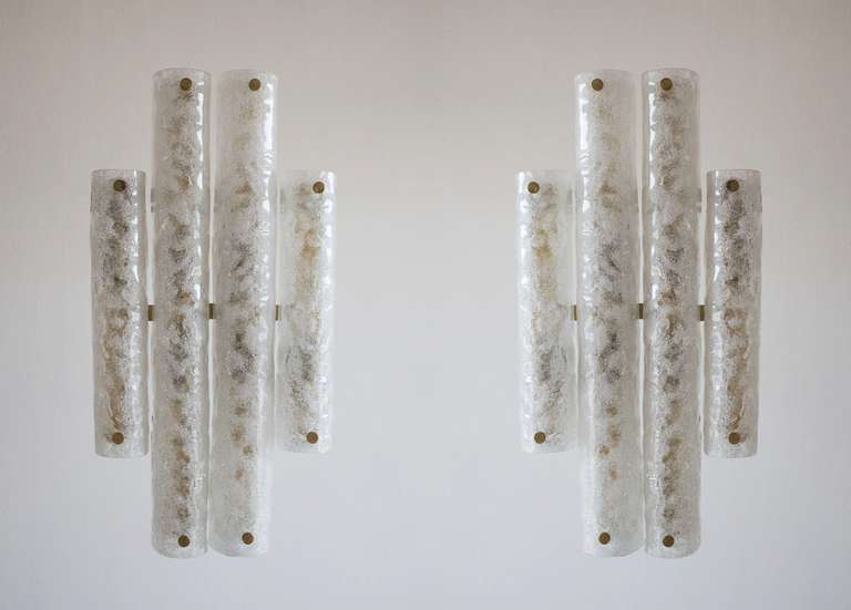 Italian pair of sconces in blown Murano glass modern clear color, 1990s.
This is a Masterpiece of Italian manufacture handcrafted sconces. They are made up of a series of half pipes in blown Murano glass. Their color is clear in a rough surface