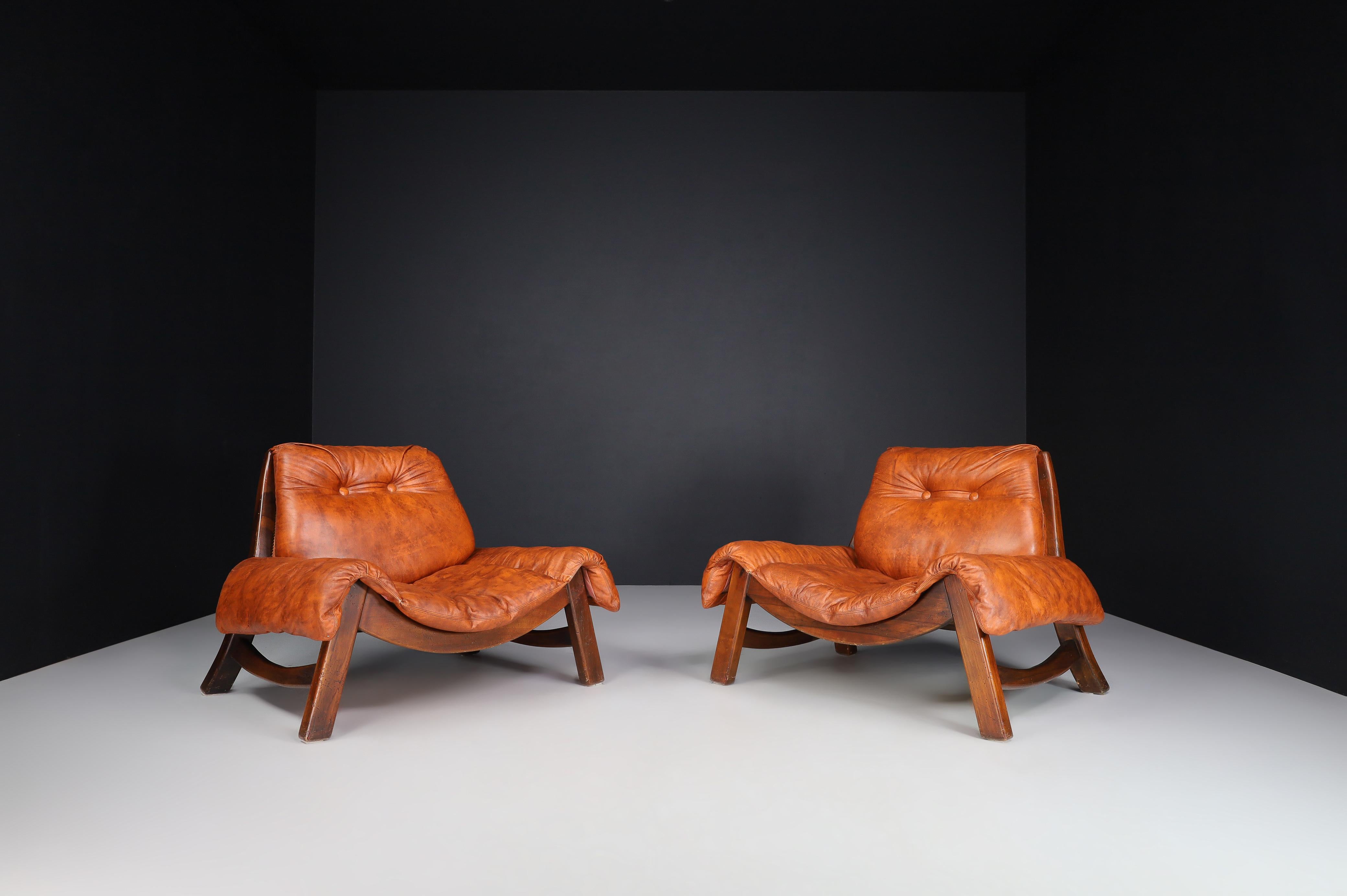 Italian pair of two large Lounge chairs in fine leather and Walnut Wood, Italy 1970s

These oversized Italian lounge chairs from the 1970s are made of solid walnut wood and fine leather. The chairs have an elegant design that combines both elements