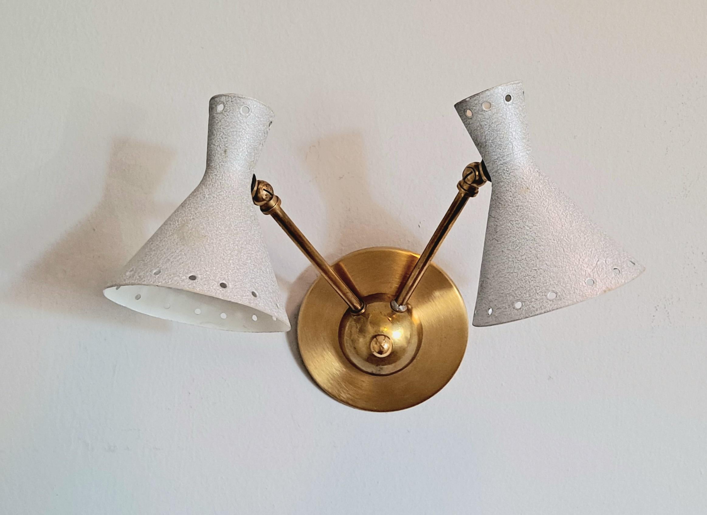 The conical wall lights are in off Silver color .The shades are supported by thin tubular brass supports that allow the shades to be maneuvered easily.  Pivoting shads helps to direct the light where you would like to be pointed.
 