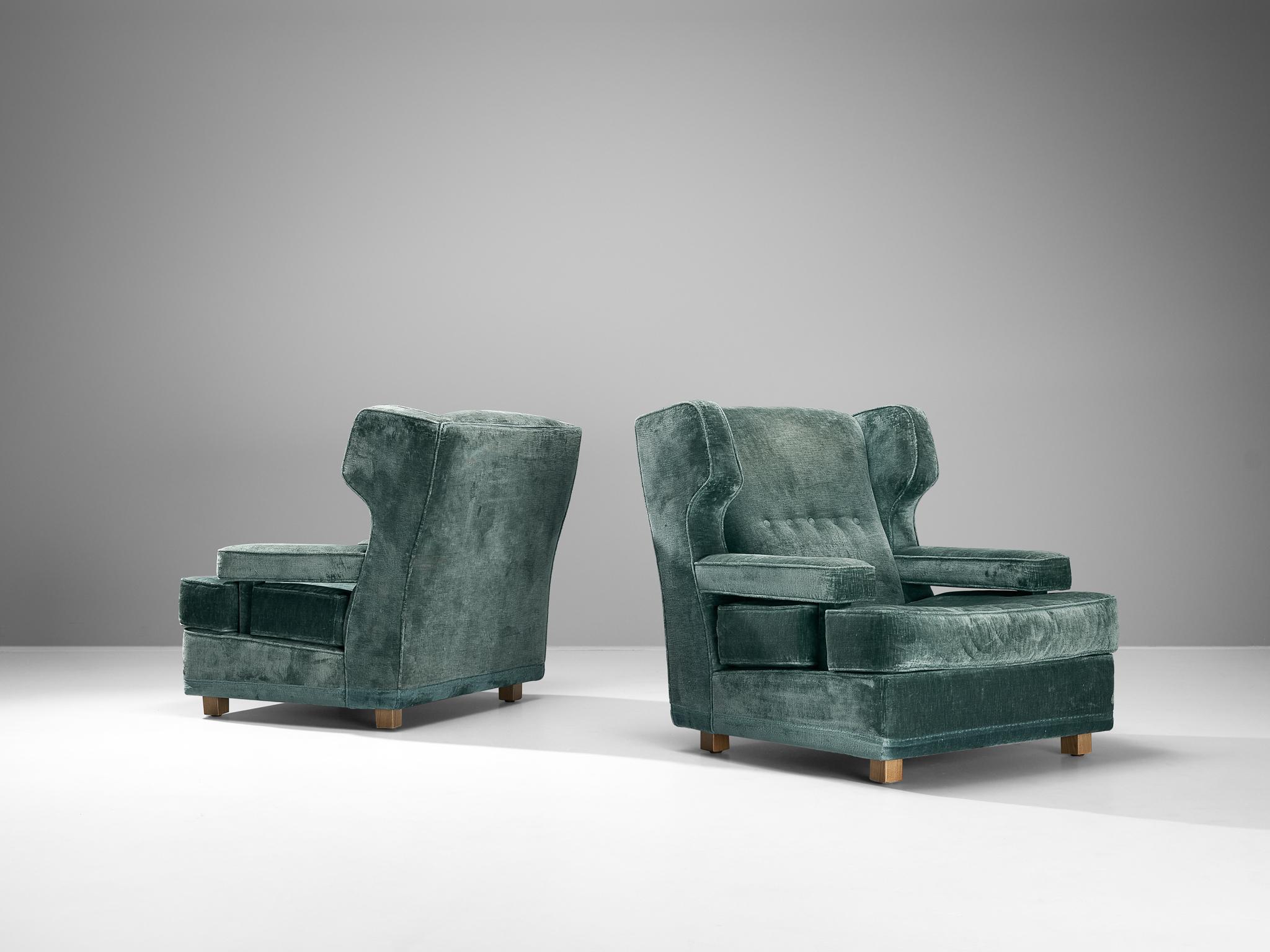 Pair of easy chairs, velvet, beech, Italy, 1940s

Made in Italy, these lounge chairs embrace a robust structure adorned with elegant ears and accentuated pointed corners. The inclined backrest, expansive armrests, and generous seat ensure the sitter