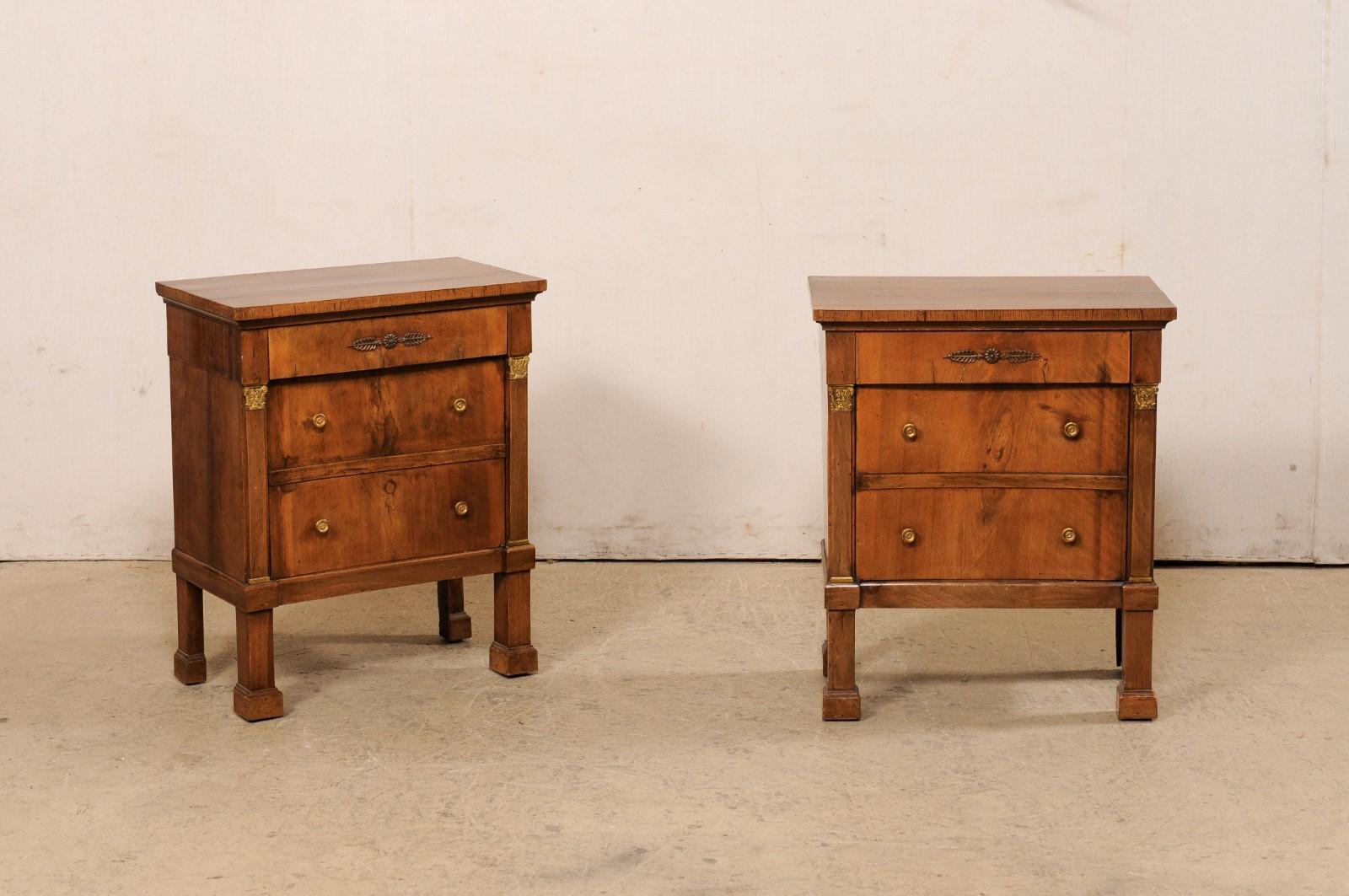 An Italian pair of Neoclassic comodini from the early 19th century. This antique pair of smaller-sized chests from Italy each feature rectangular wooden tops above a case which houses a drawer set with in the top frieze, and a single door beneath
