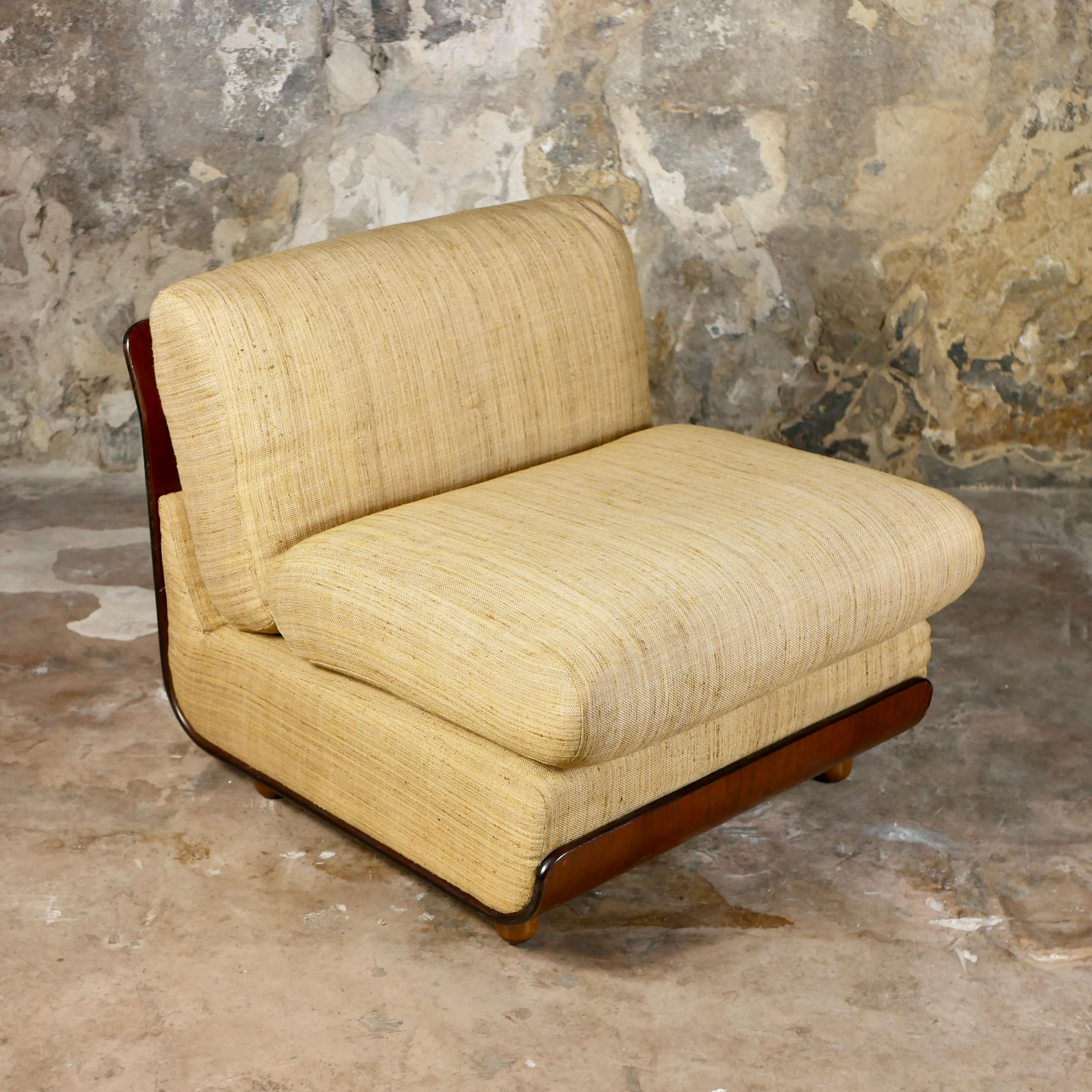 Beautiful italian armchair from the 1970s in the style of Mario Bellini’s Amanta, but more beautiful with its thermoformed wood structure and pale yellow original fabric.
Very good condition, few traces of time on wood and a tiny tear barely visible