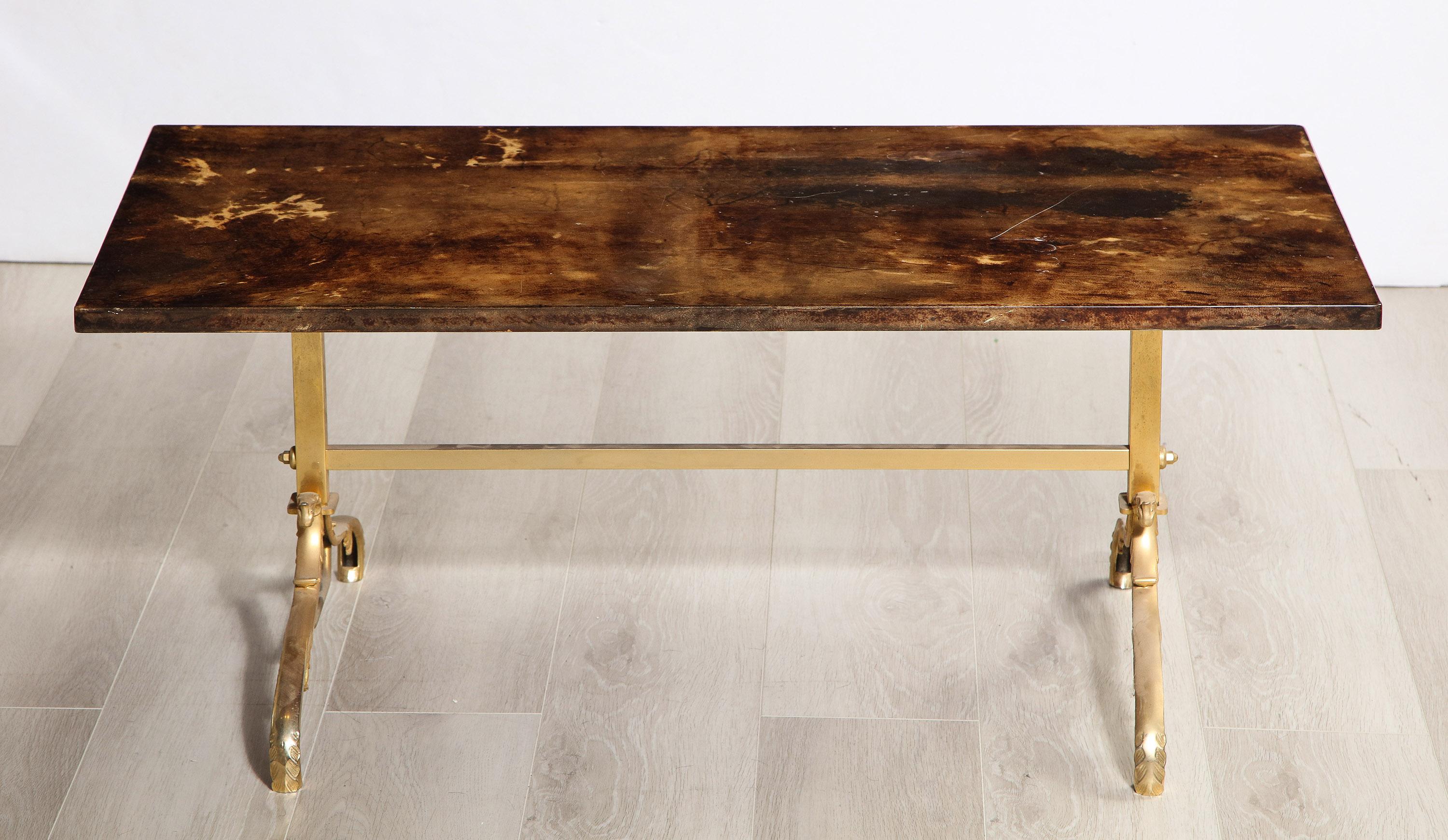 The parchment wrapped top sealed with shellac and supported by an intricate brass base.
The table is marked with a manufacturer's label on the bottom of the table.