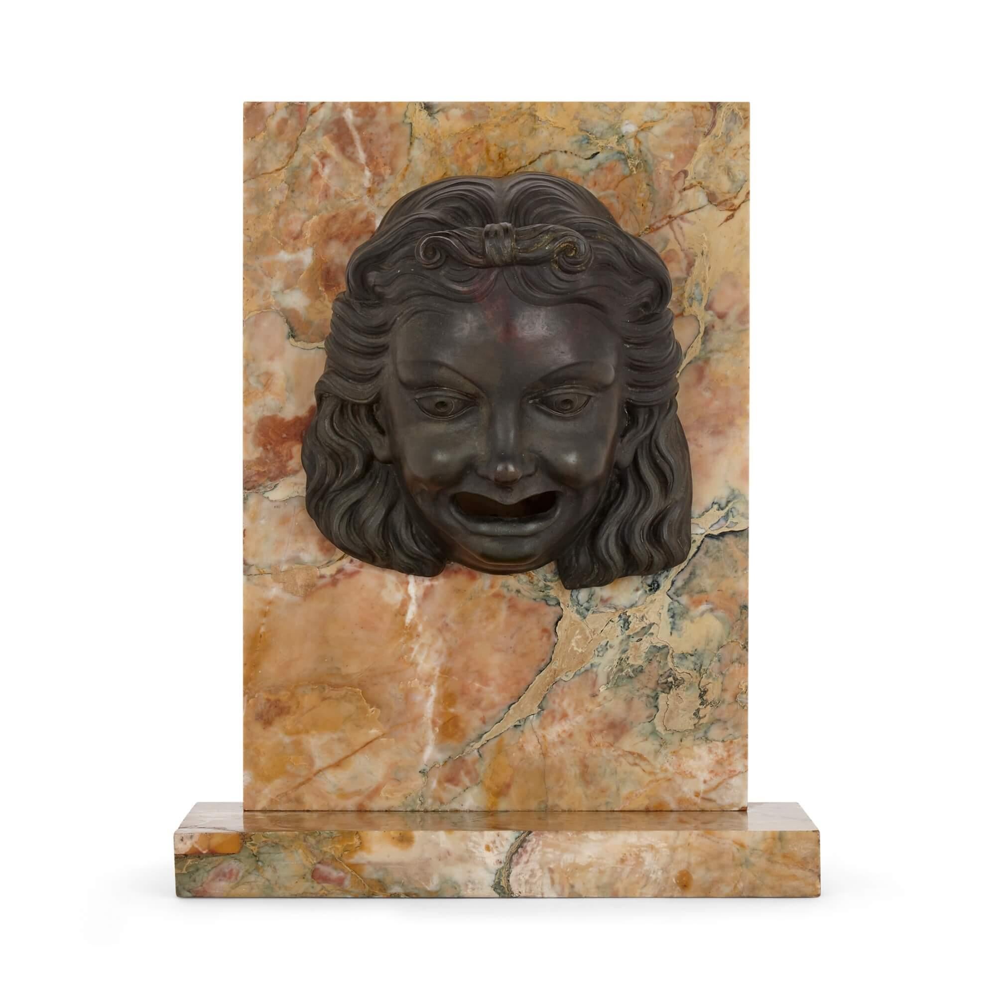 Italian patinated bronze figurative fountain mouth
Italian, 19th Century
Height 35.5cm, width 28cm, depth 13.5cm

This curious object is a patinated bronze fountain element mounted onto a yellow veined marble support. The element is a figurative