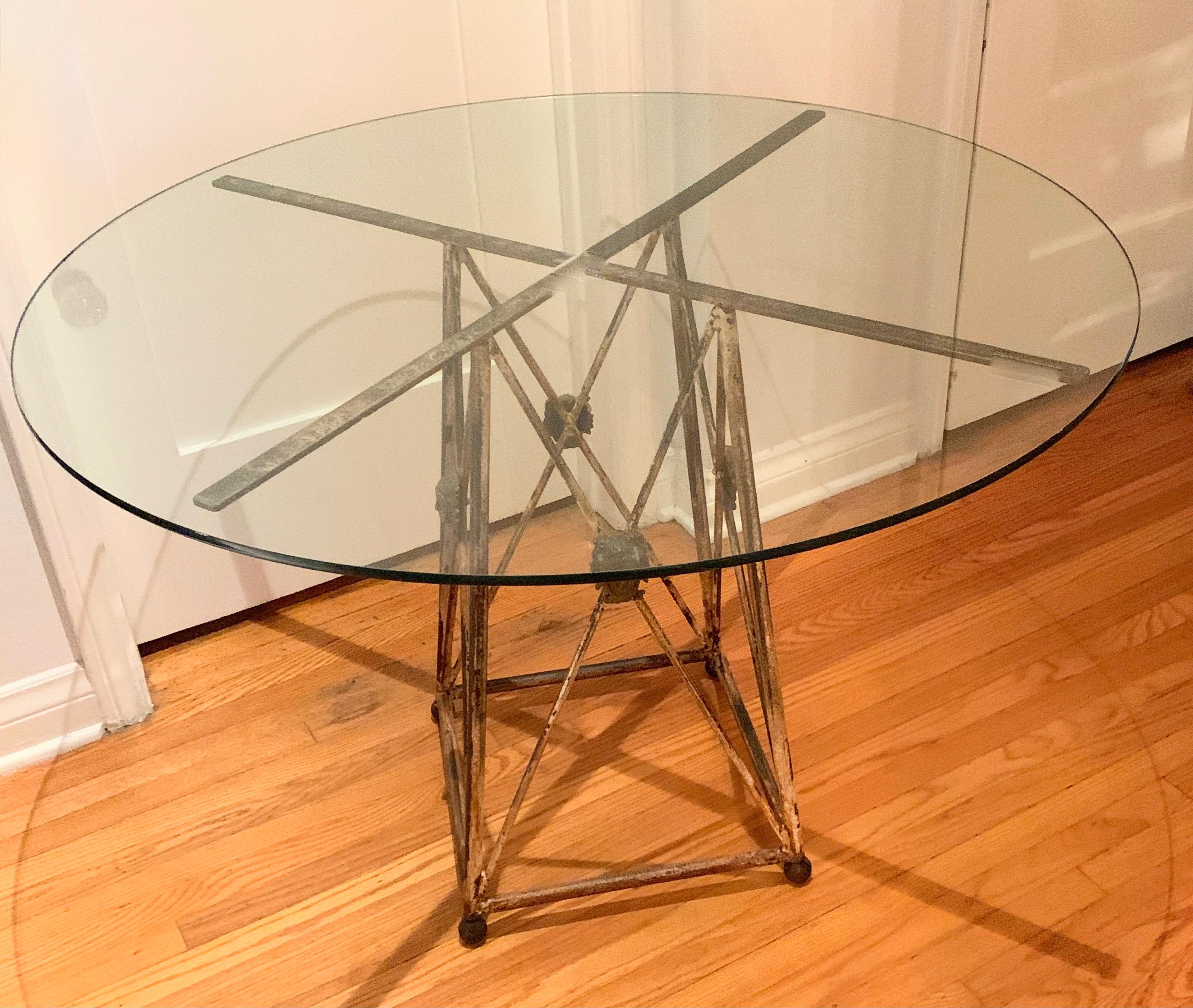 Italian patinated metal base center or dining table with Medusa Heads, with glass top. The architectural criss cross form of this table is wonderfully aged, with Medusa heads, in the style of Versace, at each intersection. We have placed glass top