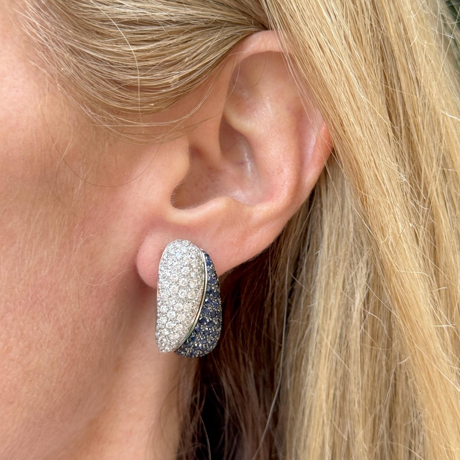 Questi moderni orecchini in oro bianco 18 carati con pavé di diamanti e zaffiri presentano un sorprendente design yin-yang, simbolo di equilibrio e armonia. Con 136 diamanti rotondi a taglio brillante per un totale di 3,00 cttw, le pietre sono di