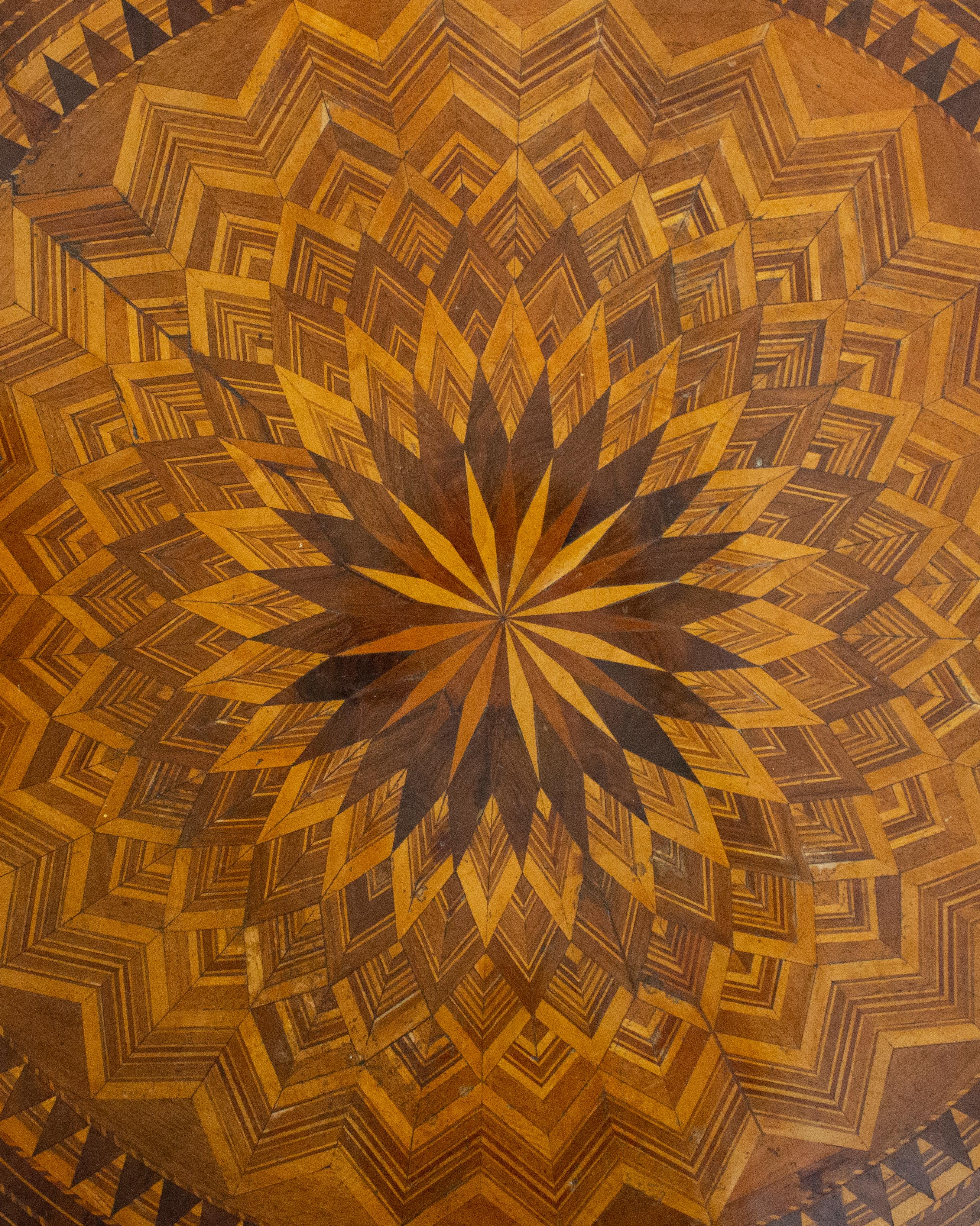 Origine : Italie, vers 1850-1890
MATERIAL : Plateau en ronce d'orme et en chêne avec marqueterie complexe en bois exotiques (dont le palissandre et le bois de roi) ; colonne balustre tournée ; base tripode sculptée.
Dimensions : Hauteur 79 cm (31.1