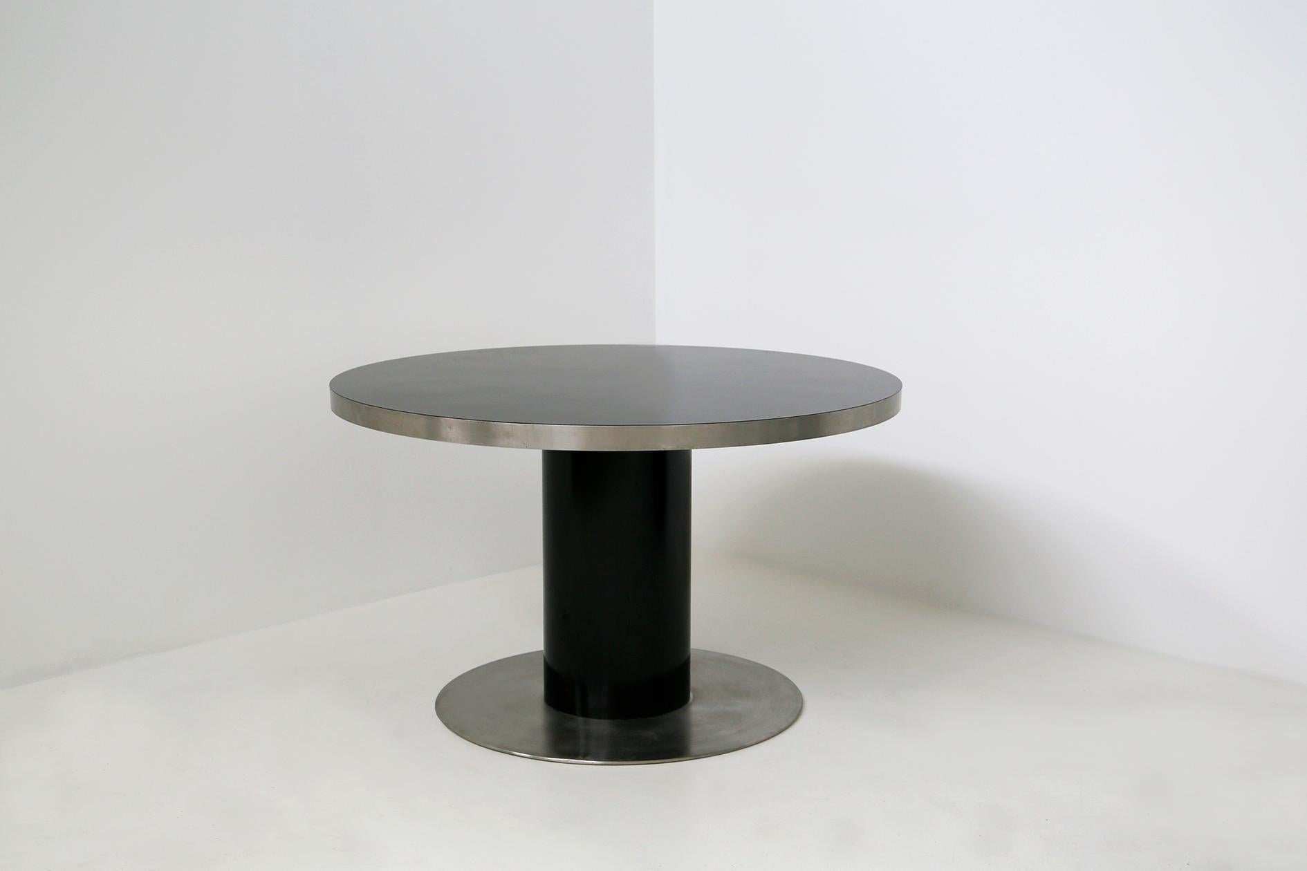 Pedestal by Willy Rizzo Dining table in wood and steel: the surface has an elegant polished black laminate top framed by a 5 cm thick steel band. The pedestal is in black laminate like its top which rests on a thick round steel plate. The base has a